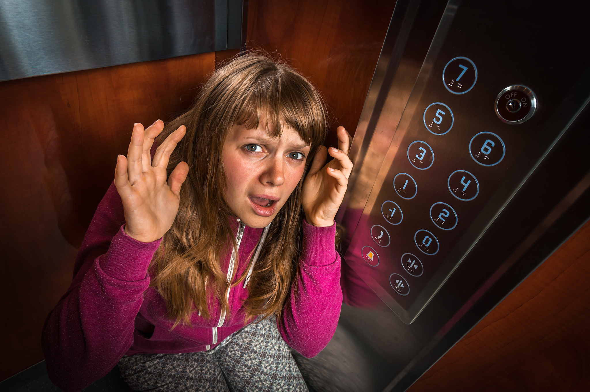 shocked woman with claustrophobia in the moving elevator