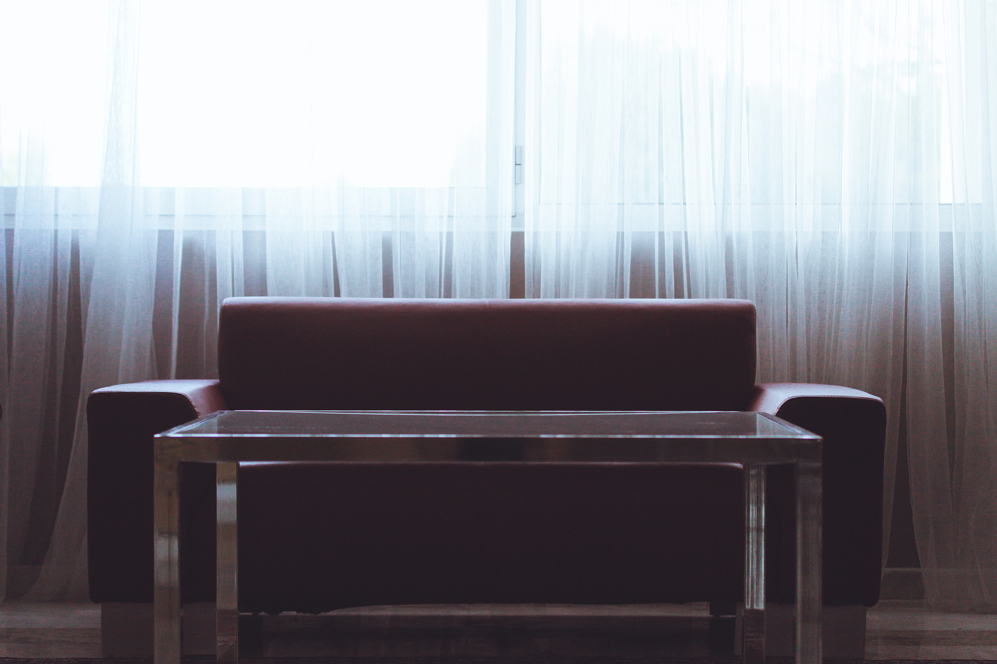sofa and table against window with curtains