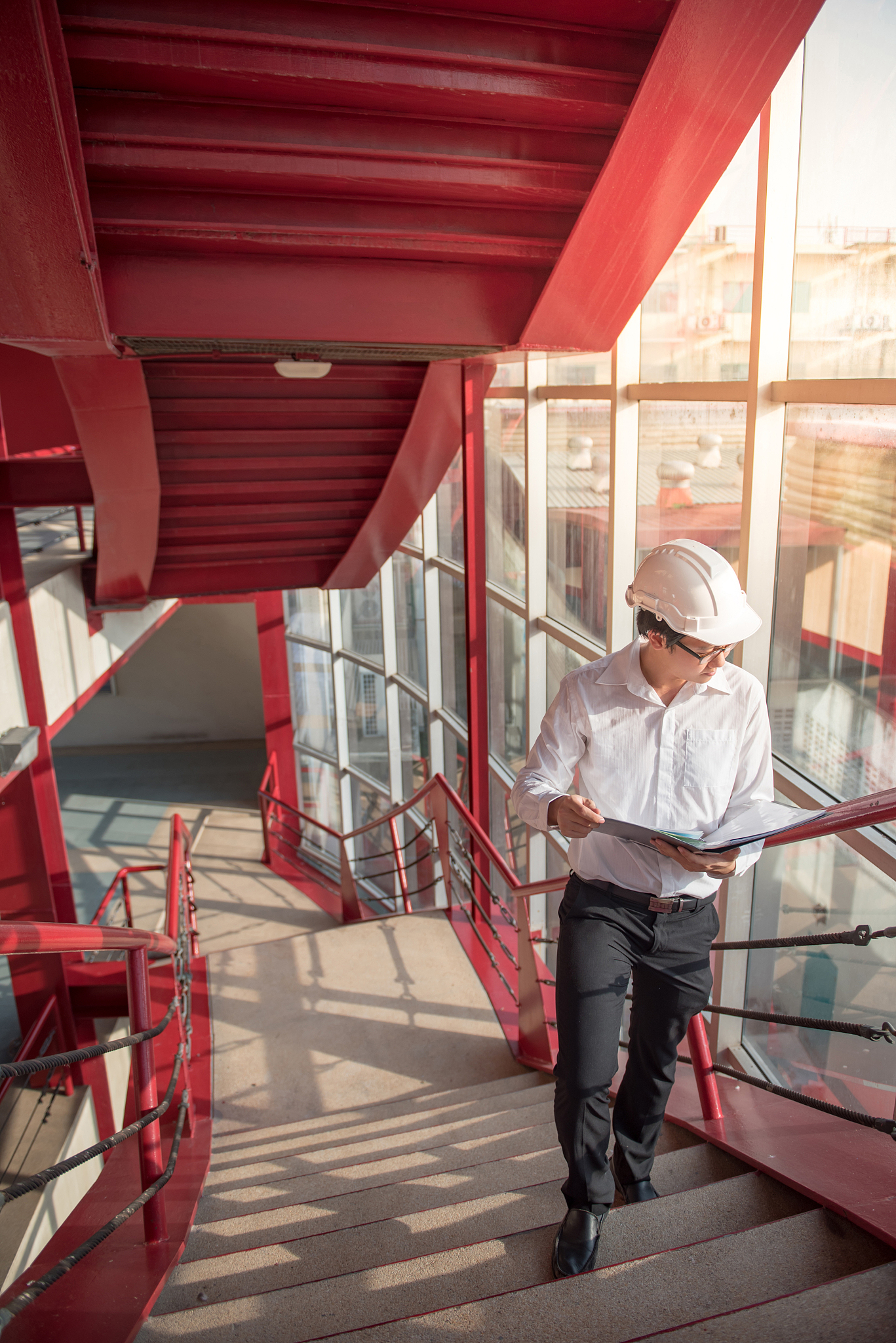 young asian engineer holding files at construction site