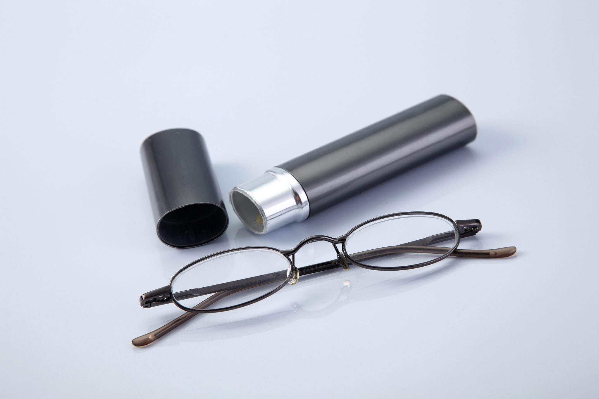 close-up of eyeglasses and box against white background