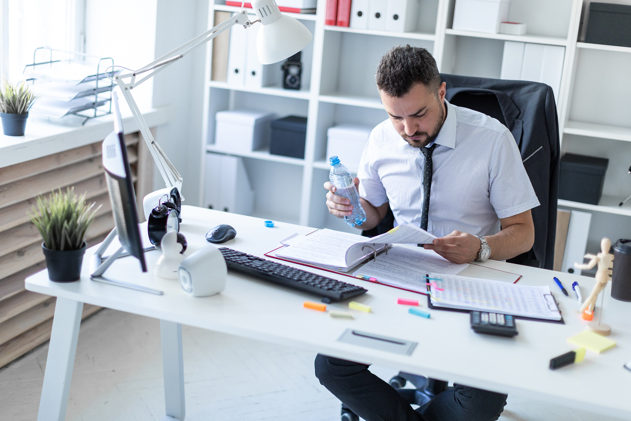 a man is sitting at a table in the office, working with document