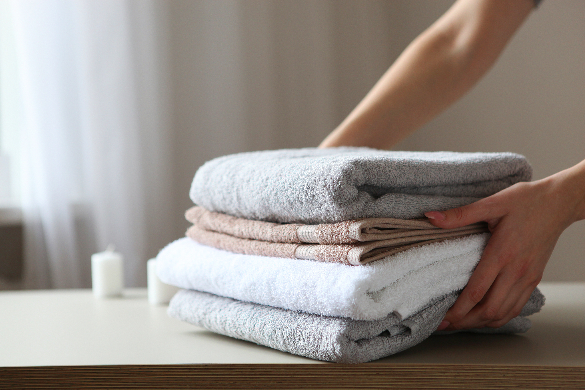 a stack of fresh towels in female hands.