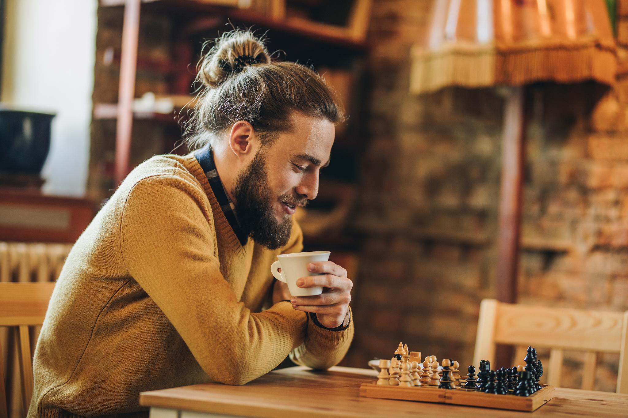 happy man thinking of his next chess move in a cafe.