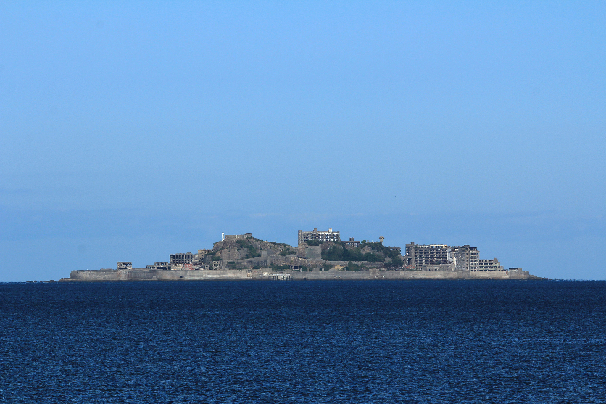 buildings by sea against blue sky
