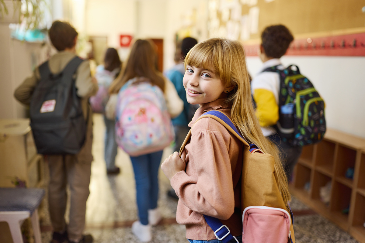 快乐的小学女生在教学楼走廊里玩耍