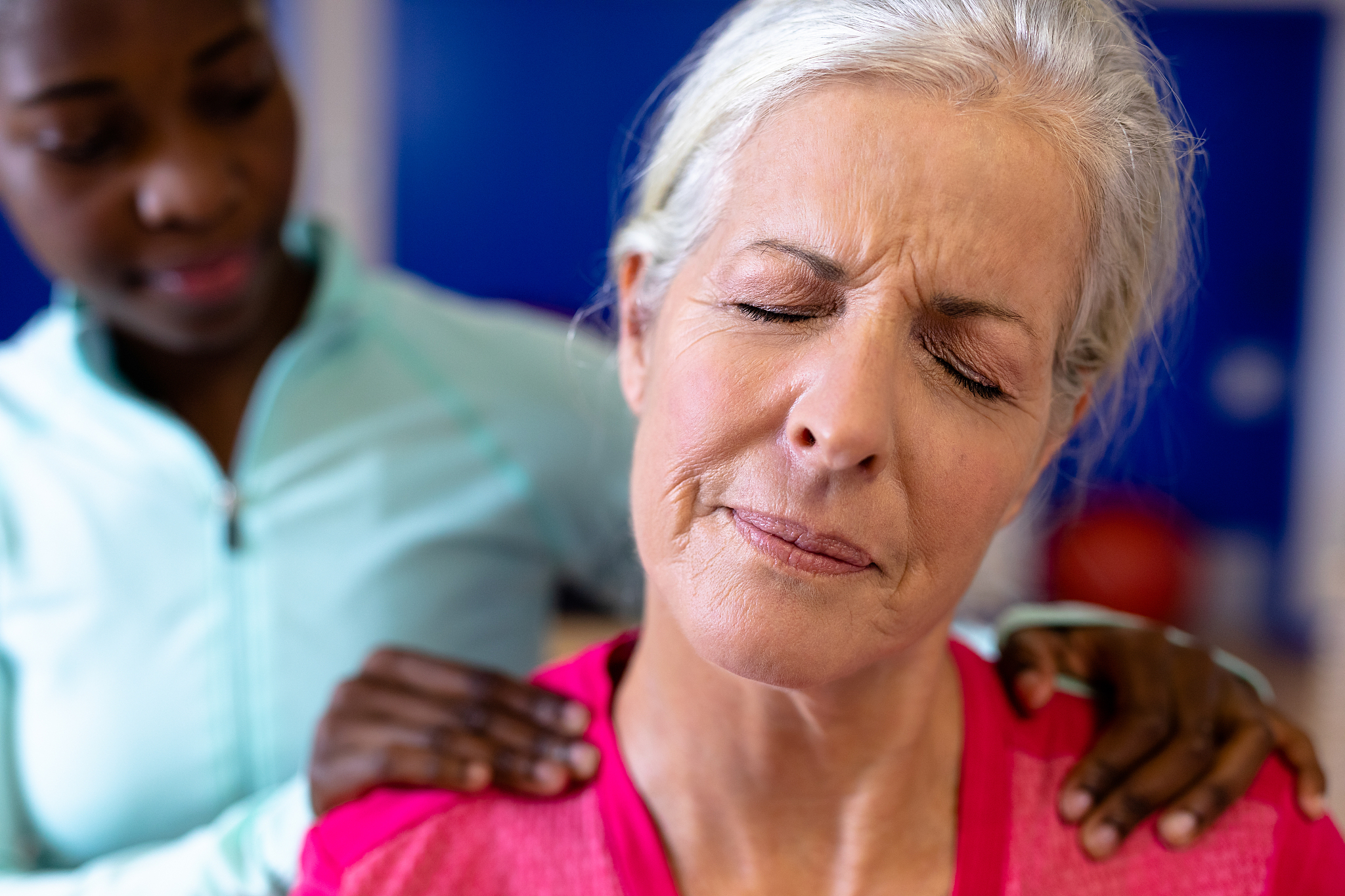 female physiotherapist giving back massage to active senior woma