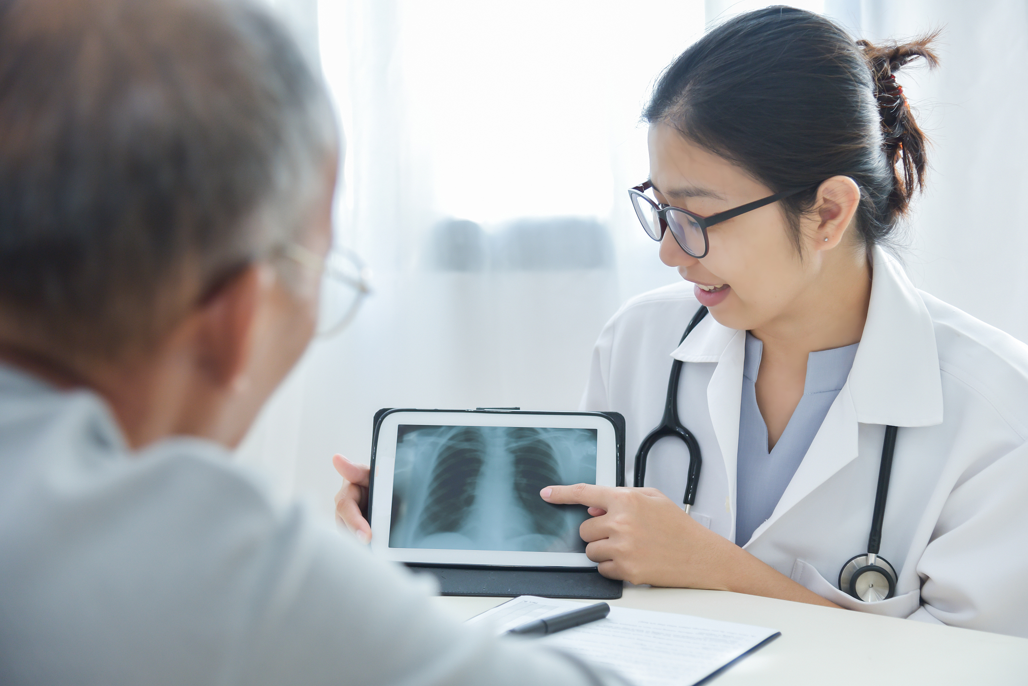 young female doctor discussing with senior man patient.