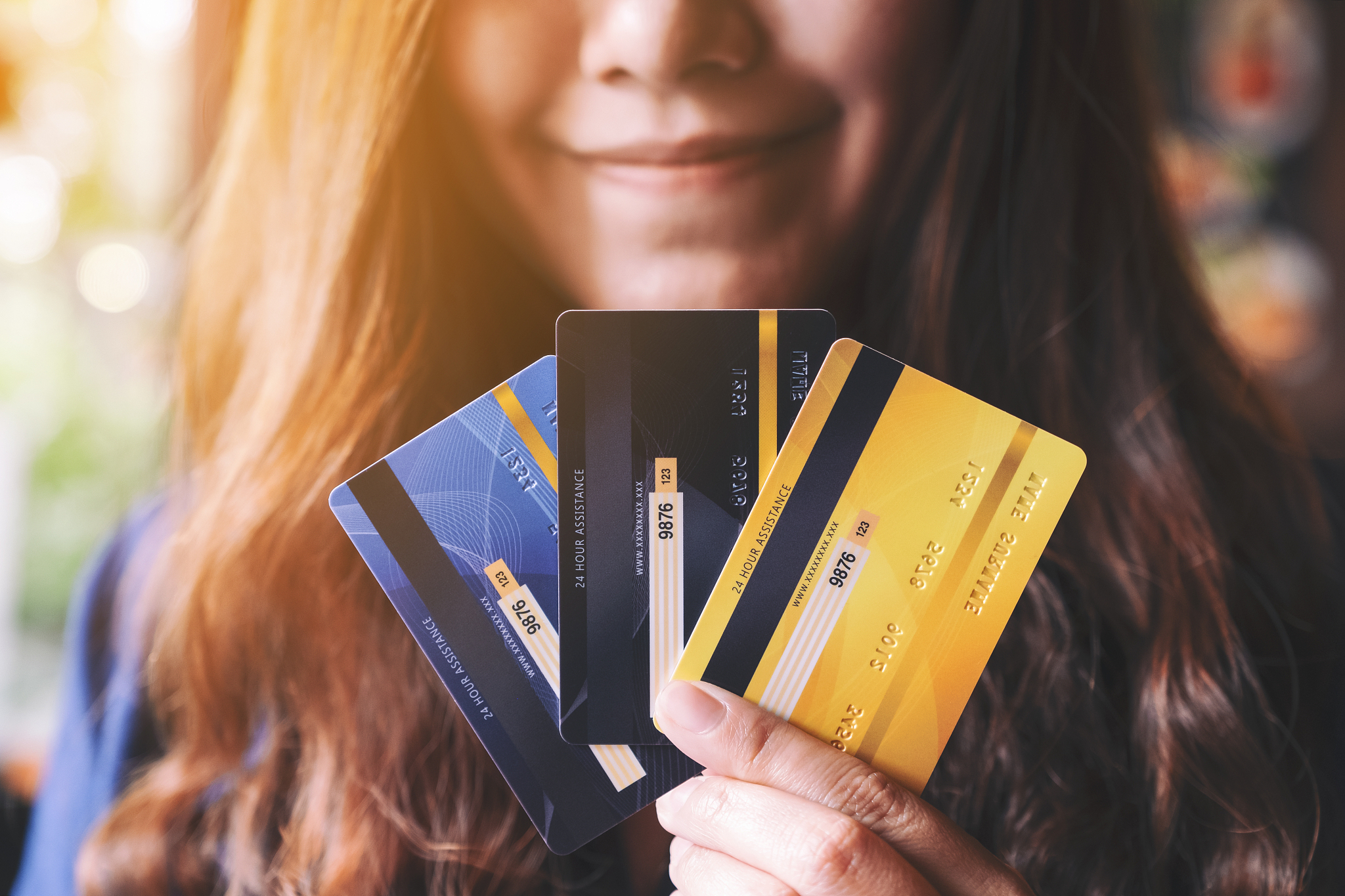 a woman holding and showing credit cards