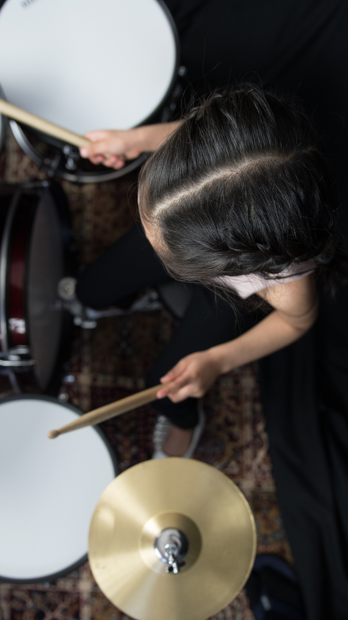 5 year old girl practices the drums
