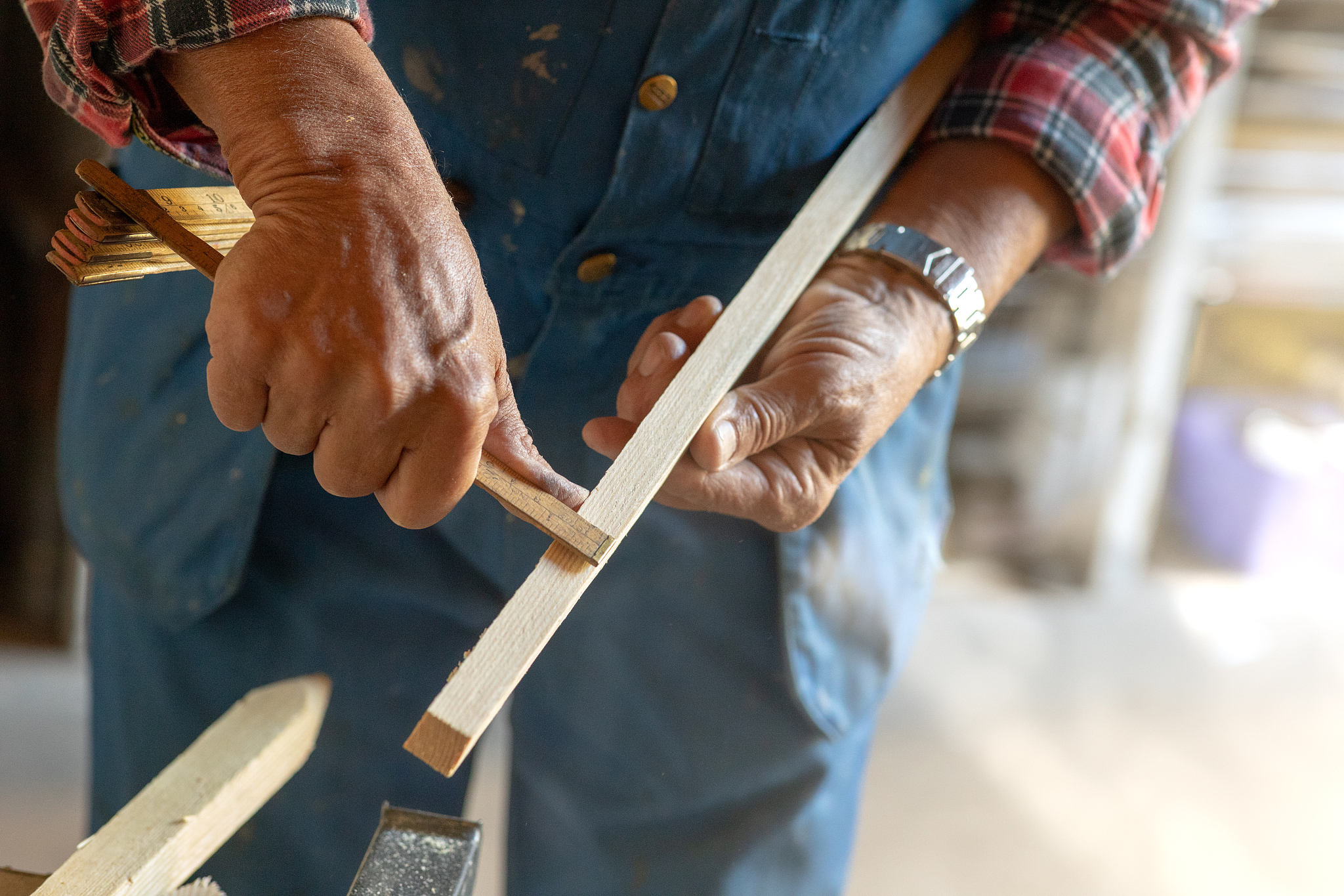 man measuring a piece of wood