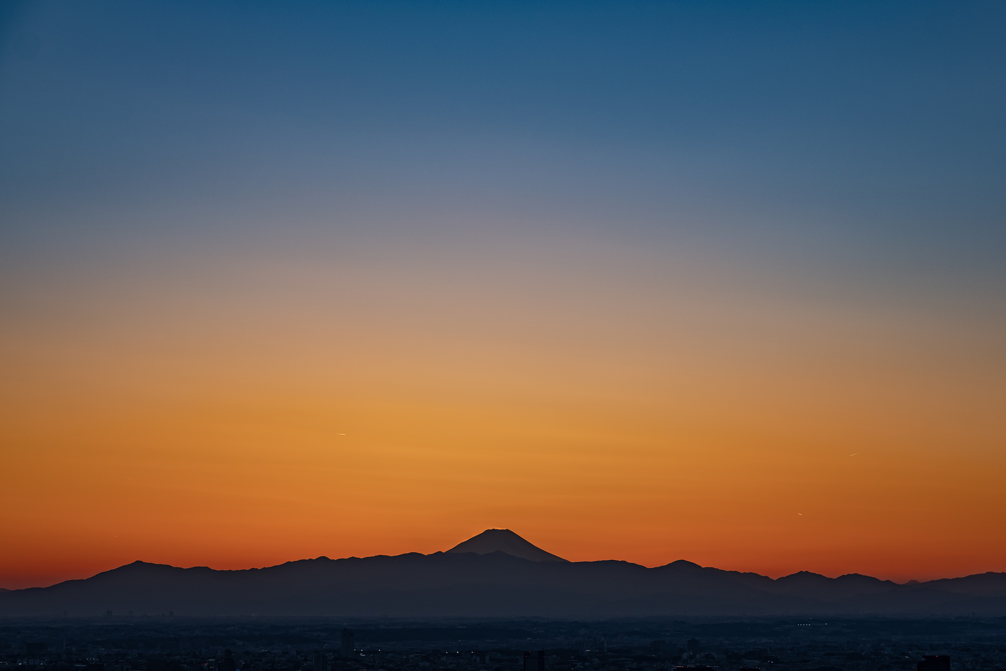 the sky after sunset and the silhouette of mt. fuji seen from th