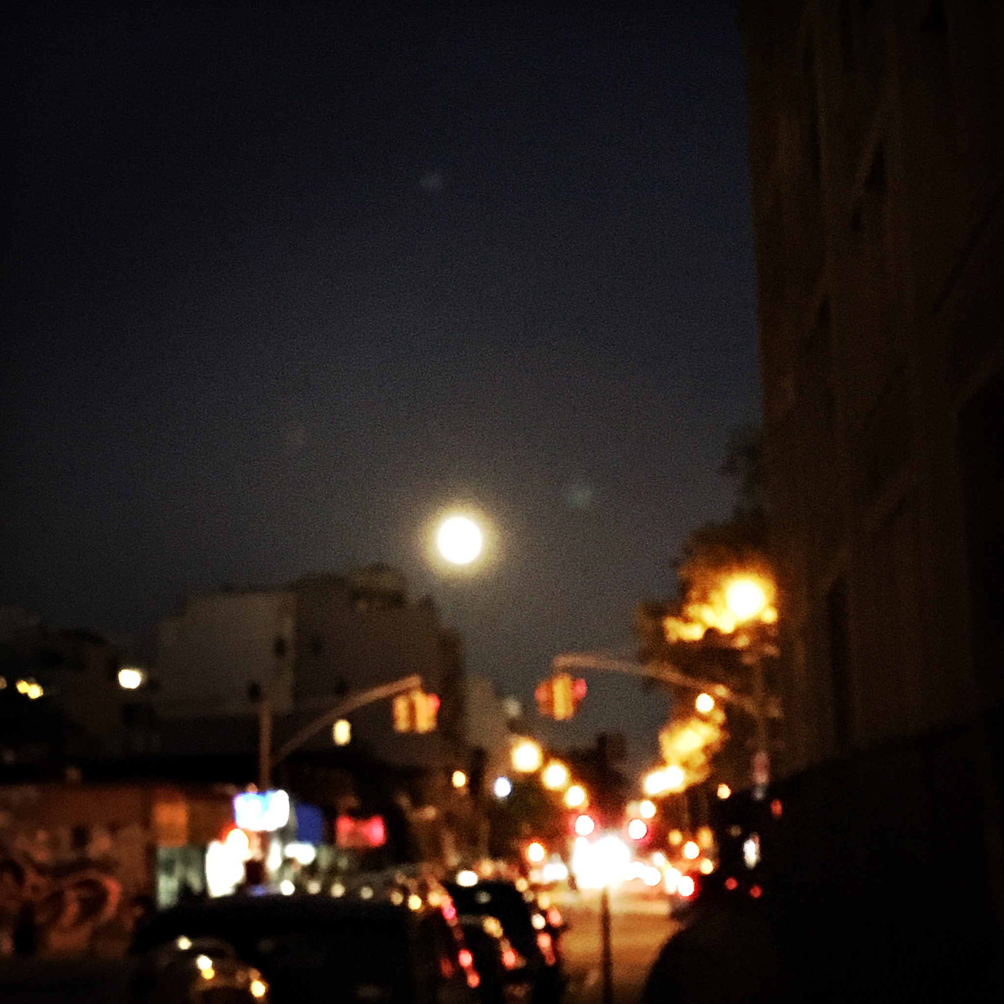 full moon over busy city street