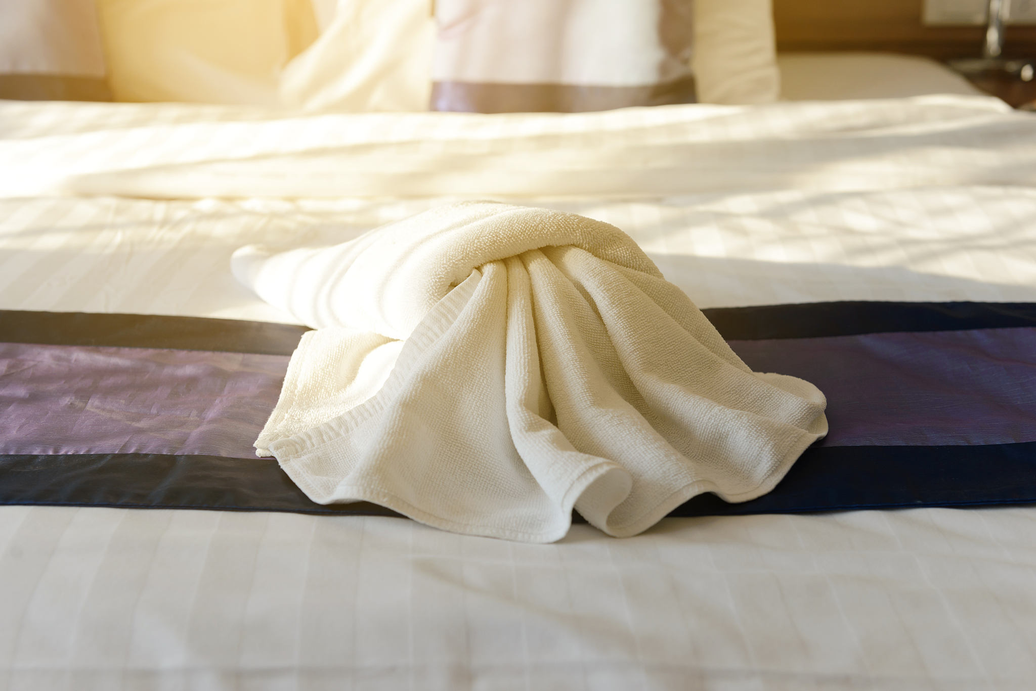 white towel decoration on bed in bedroom hotel