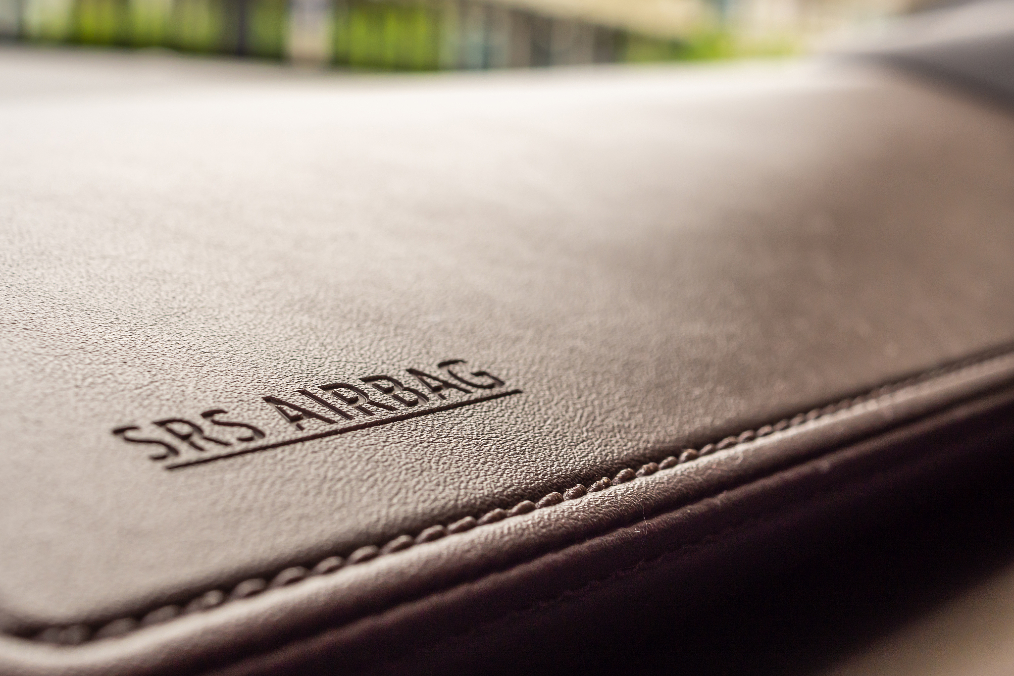 airbag safety sign on brown leather texture in modern car