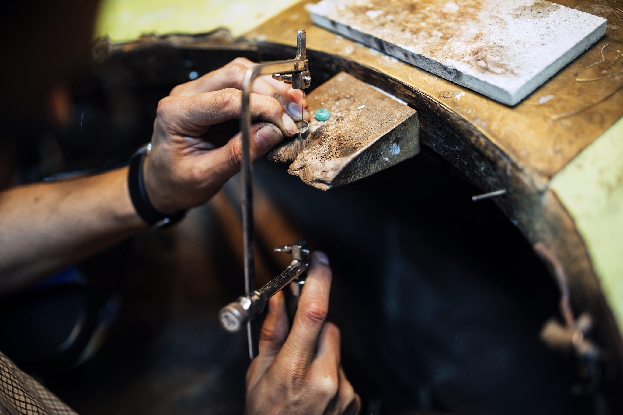 jeweler using saw to create jewelry