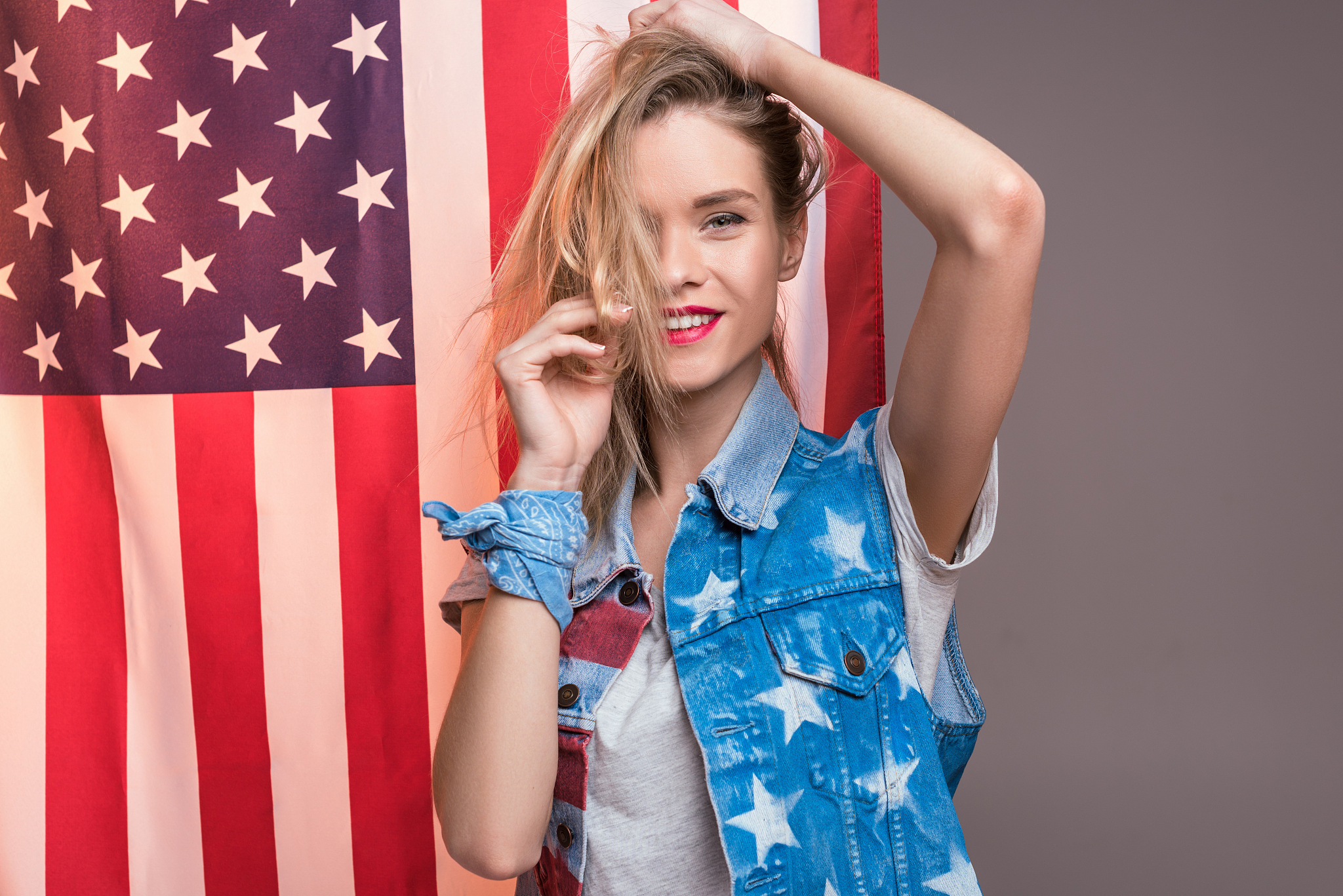 woman posing in front of usa flag, independence day of america