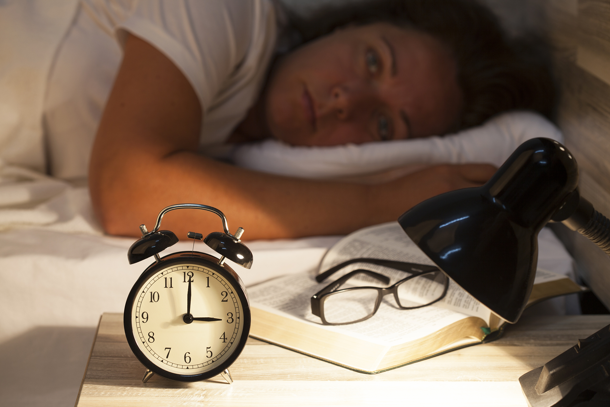 woman lying in bed suffering from insomnia