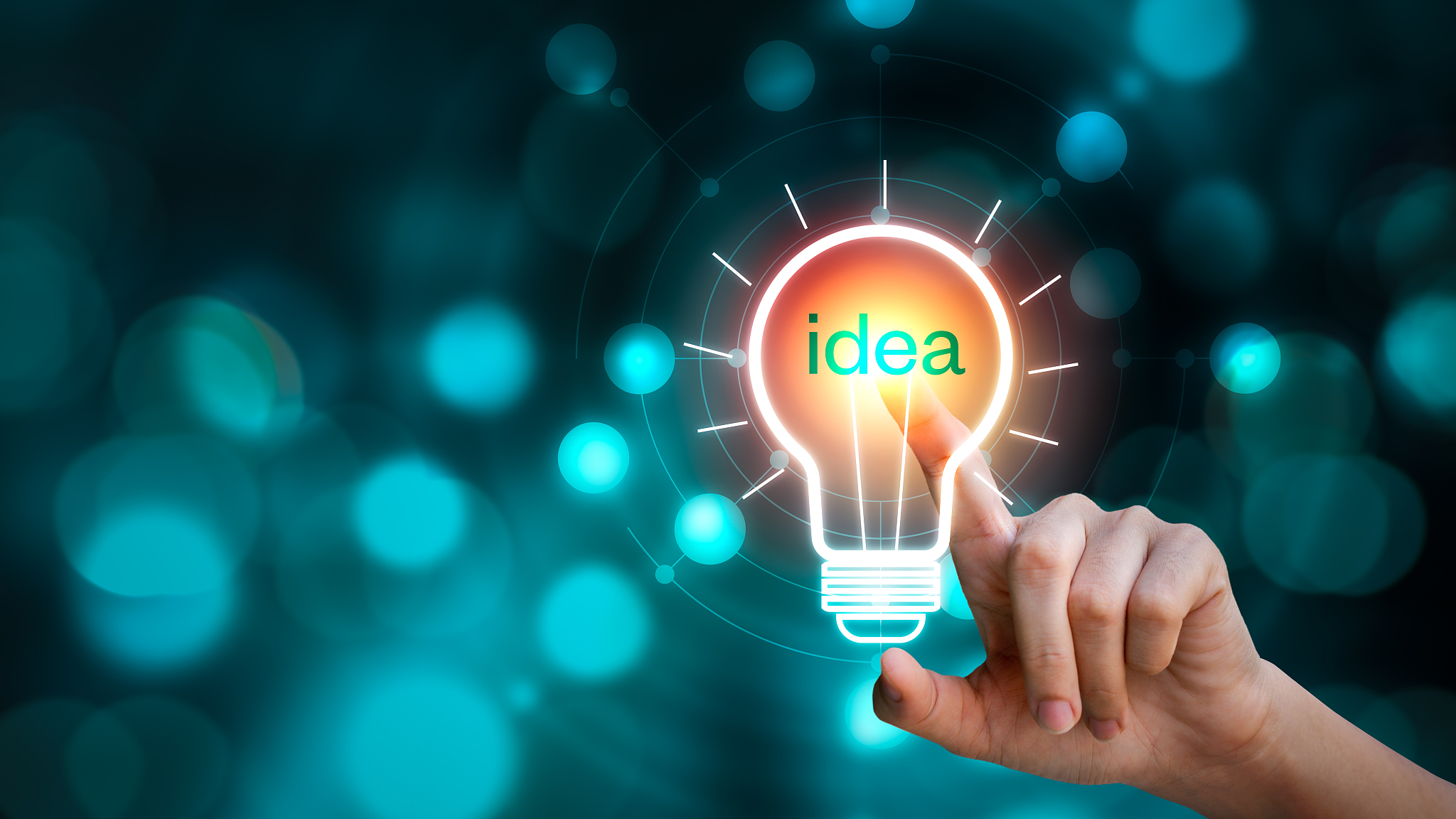 hand touching the light bulb sign with idea text on blurred back