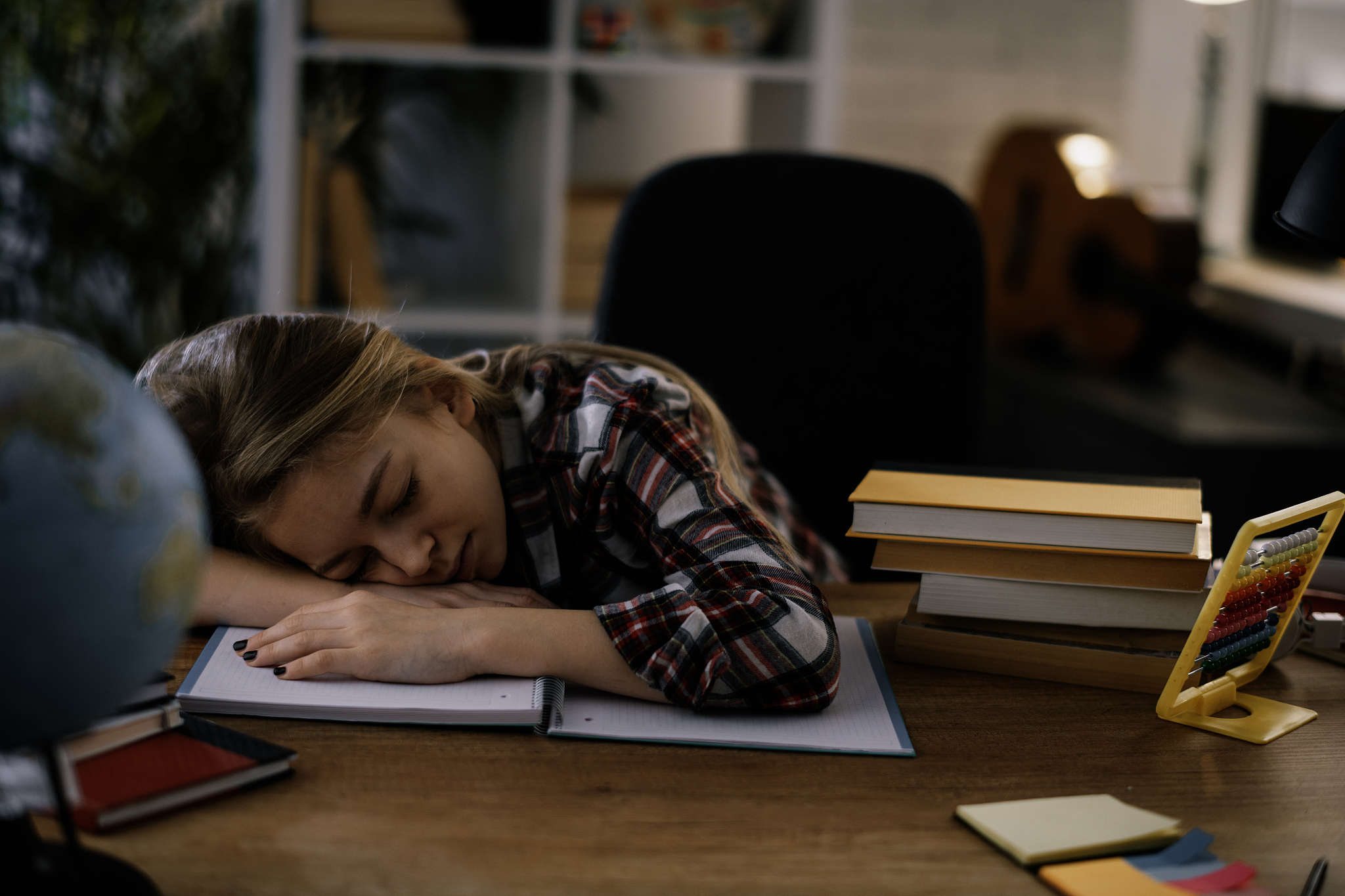 tired little girl doing homework at home.