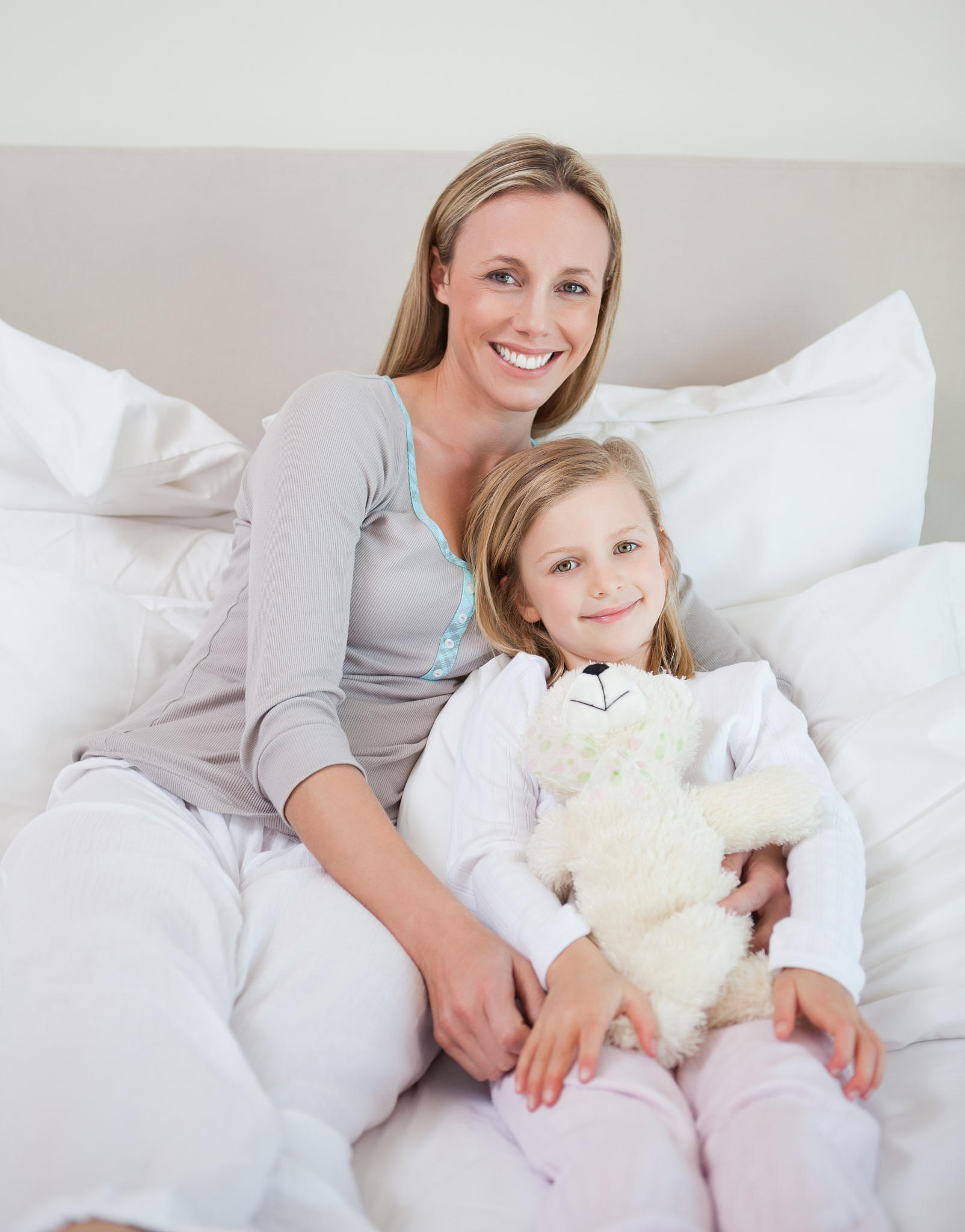 mother and daughter sitting on bed