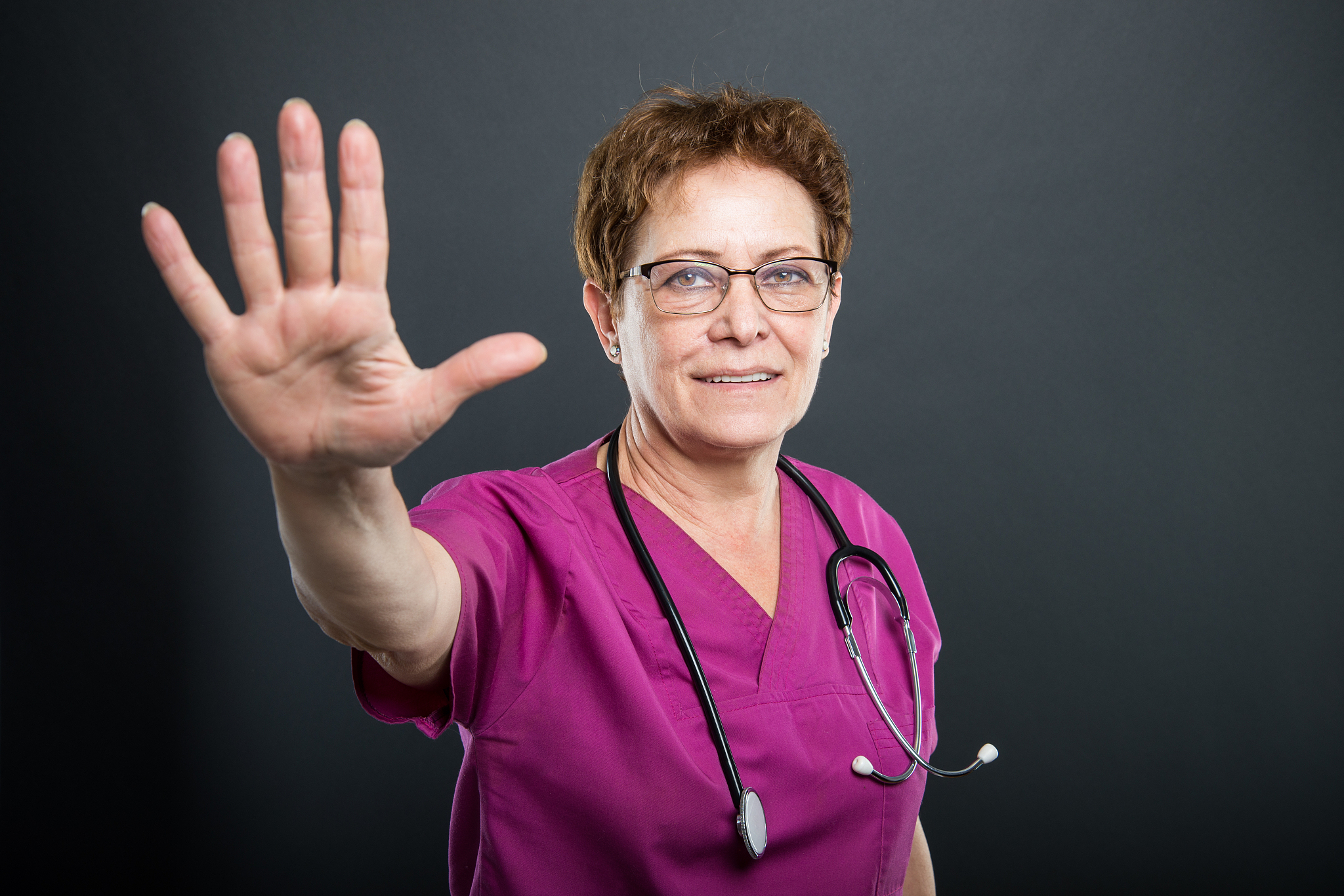 portrait of senior lady doctor showing number five