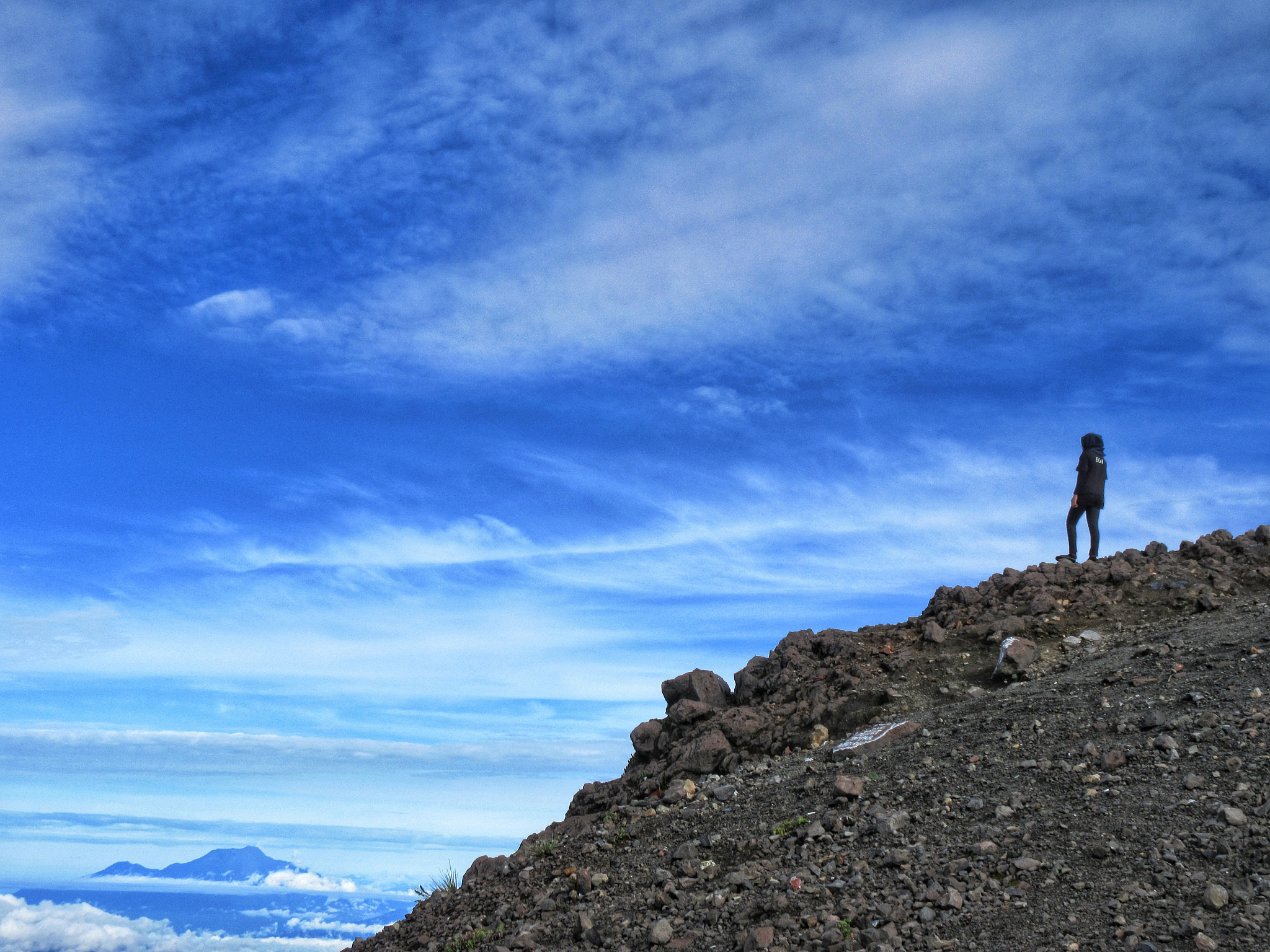 person standing on mountain against sky