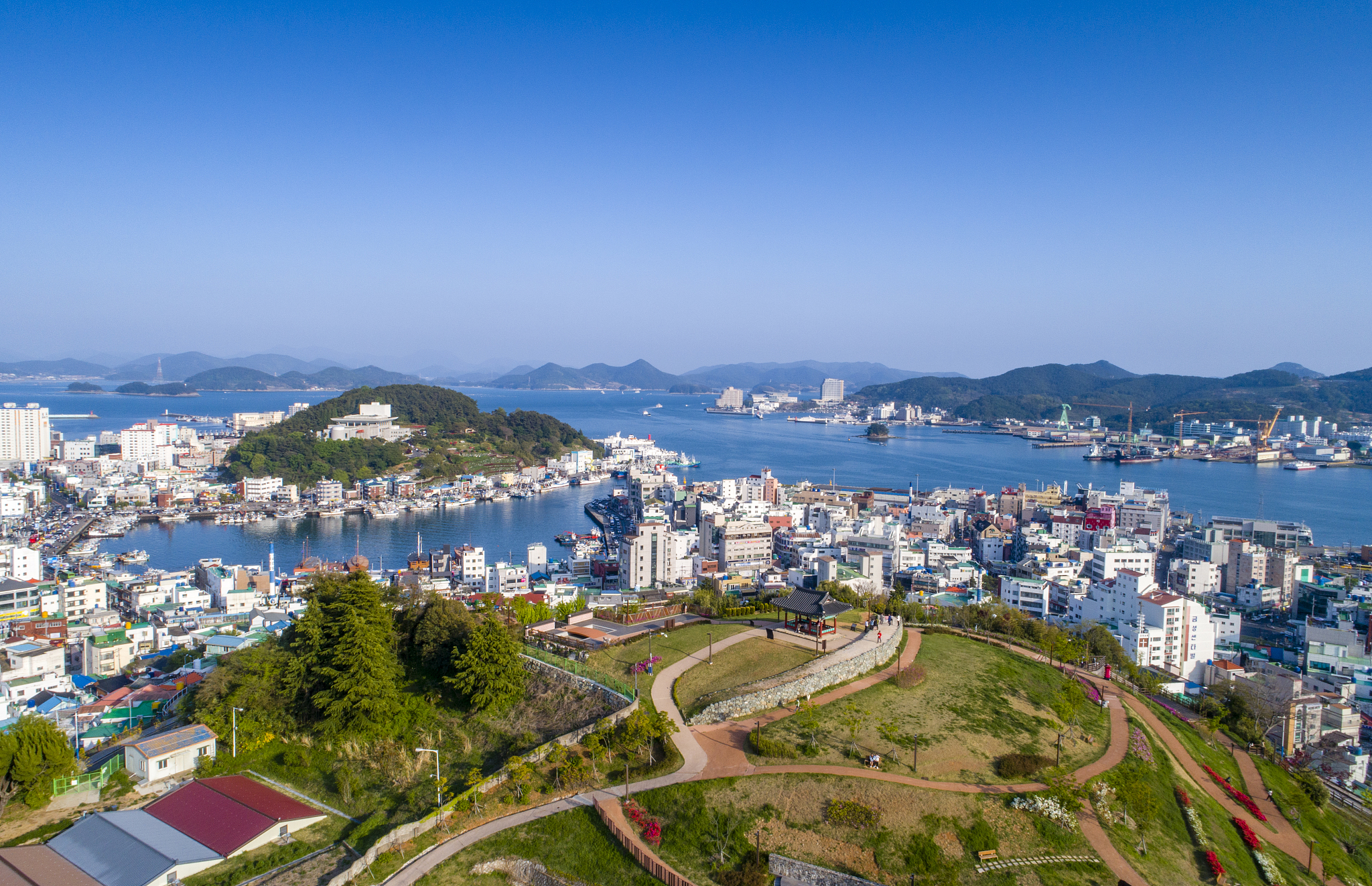 high angle view of city by sea and buildings against sky