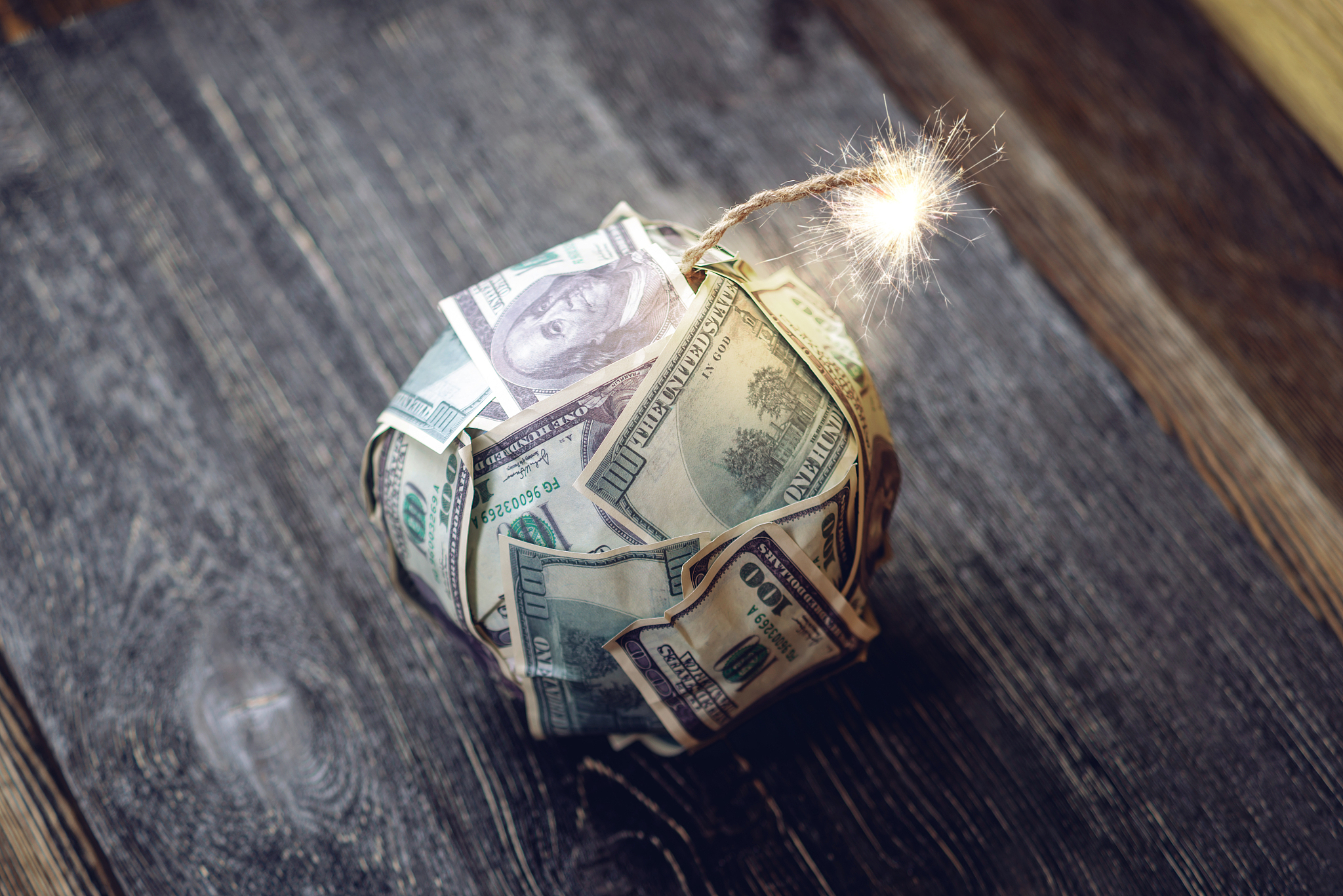 bomb of money, hundred-dollar bills with a burning fuse. explosi