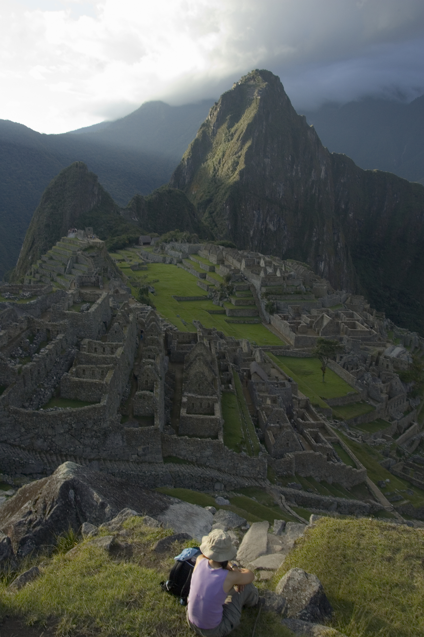 peru, cuzco, female tourist above machu picchu at sunset, rear v