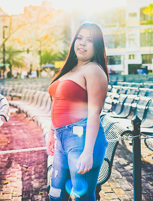 latina woman in tube top poses confidently in a city urban portr