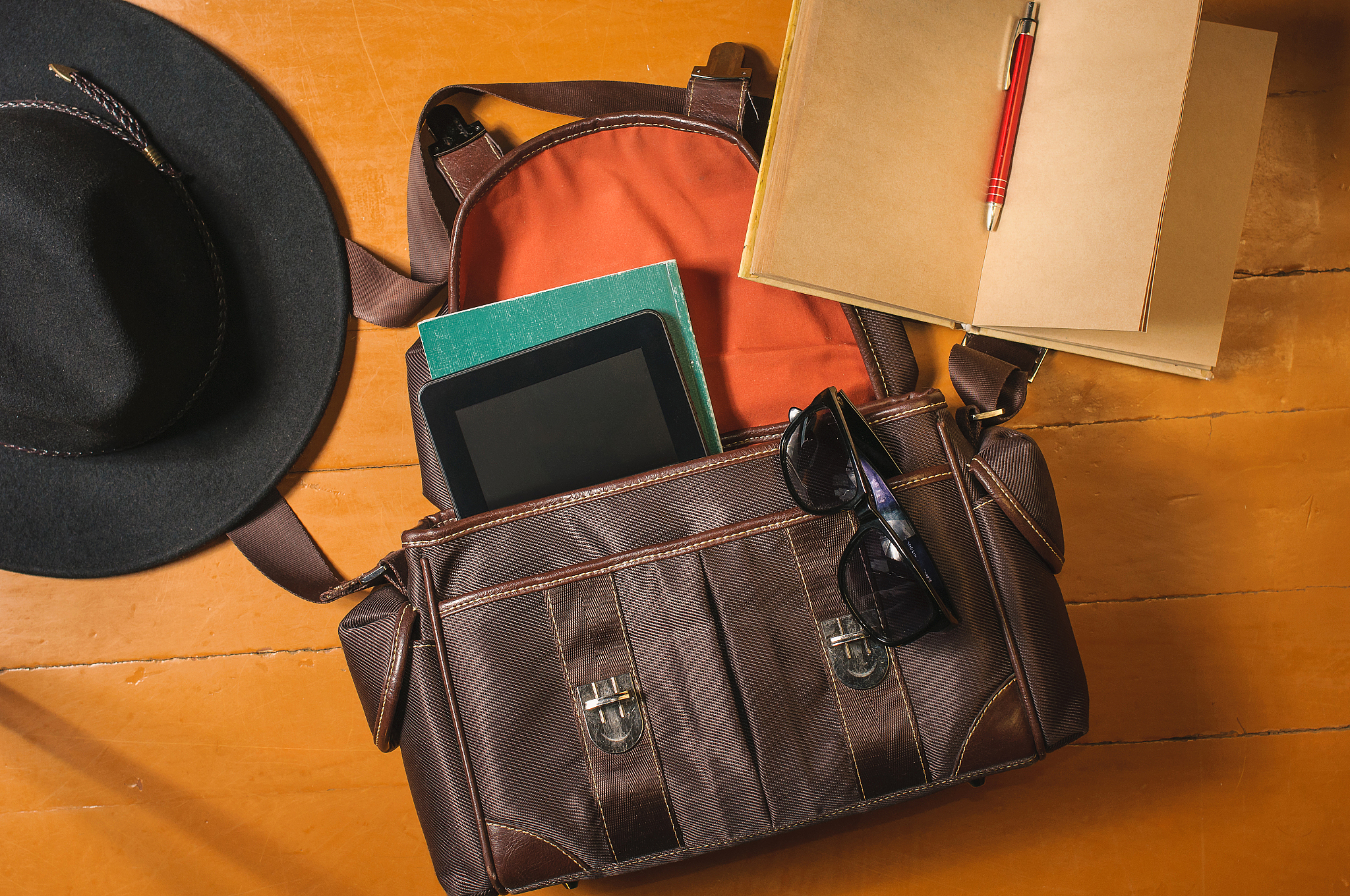 travel accessories on wood: bag, vintage diary, sunglasses and h