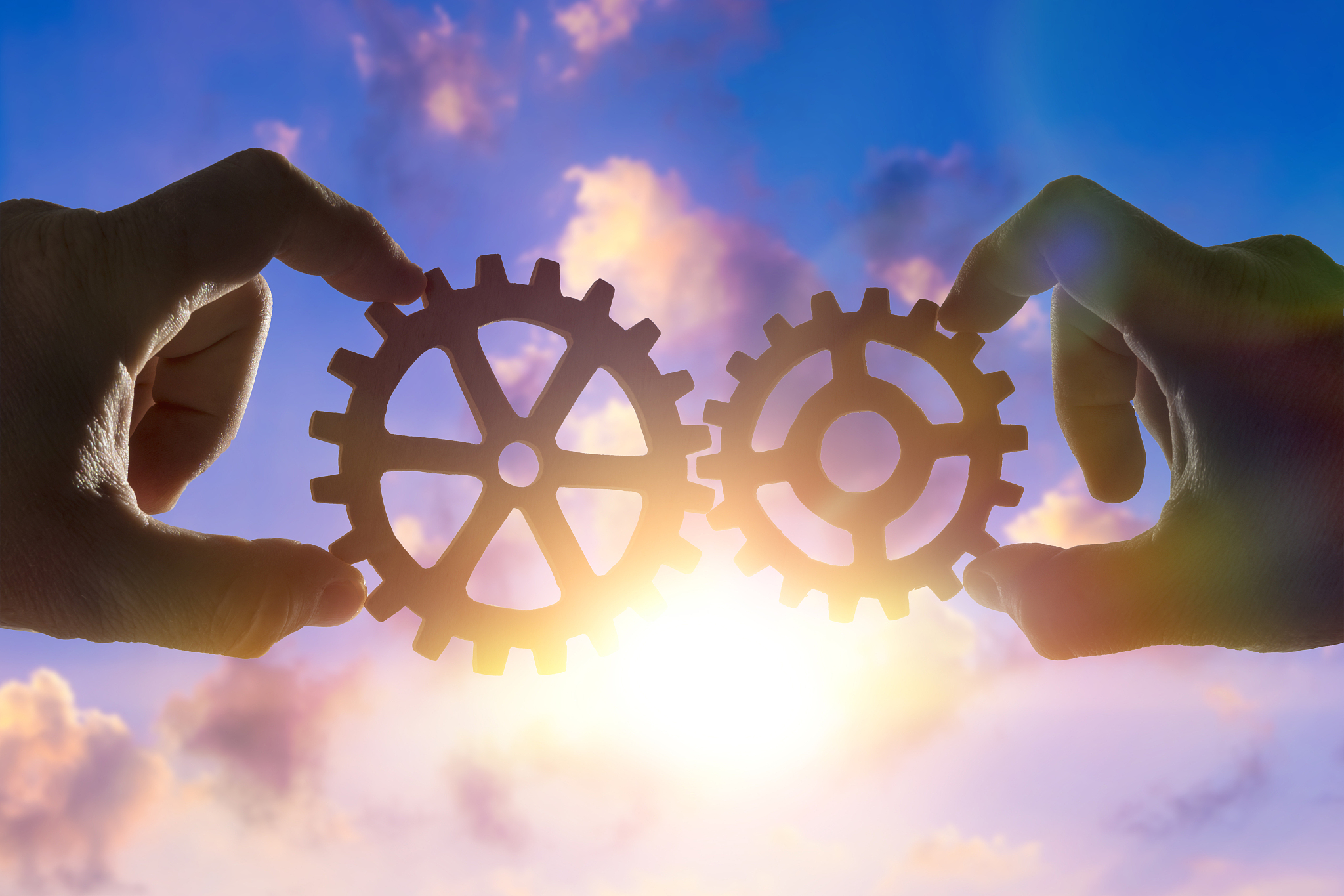 two hands connect the gears, the details of the puzzle. against 