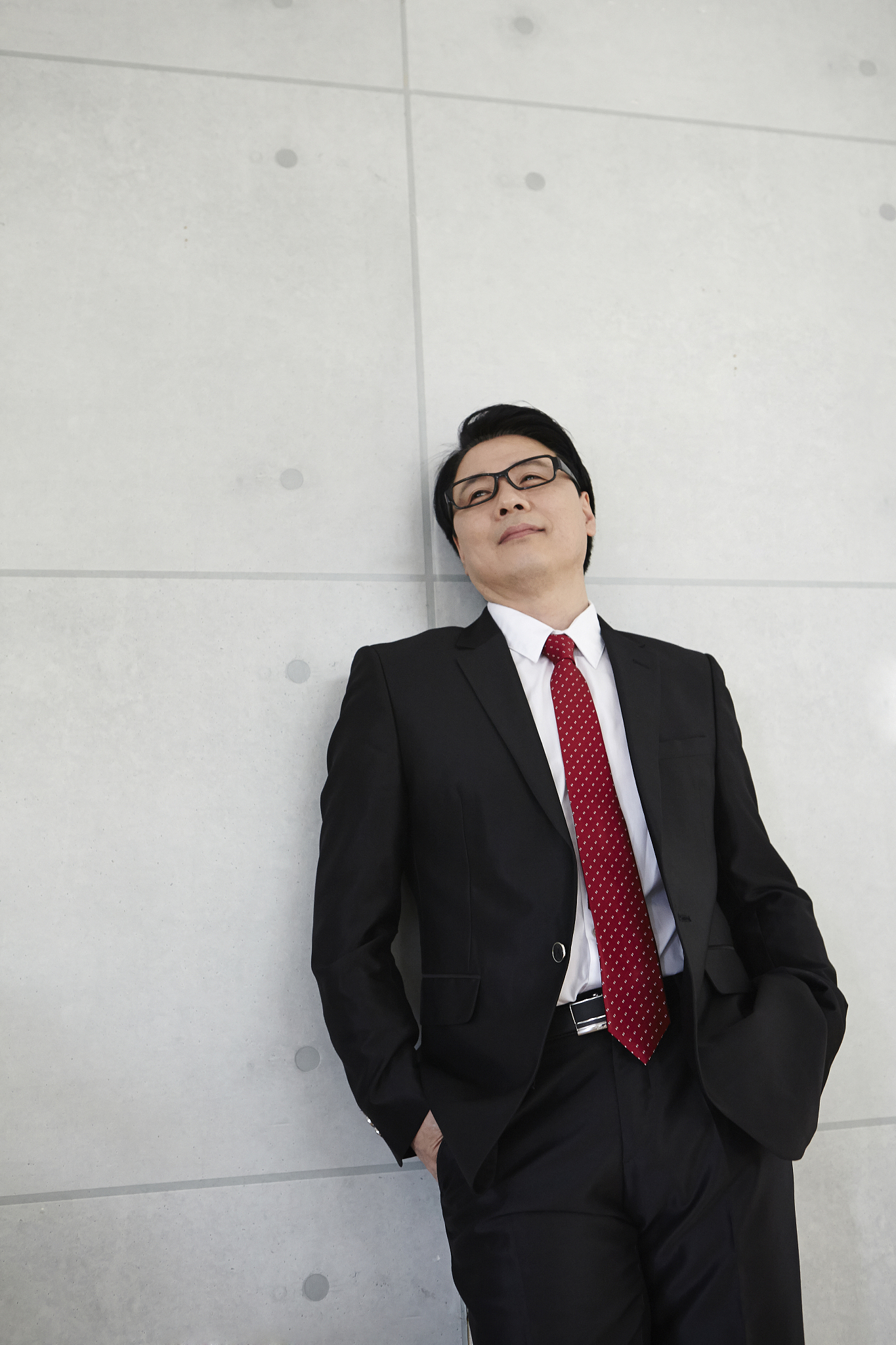 photography of businessman leaning on the wall