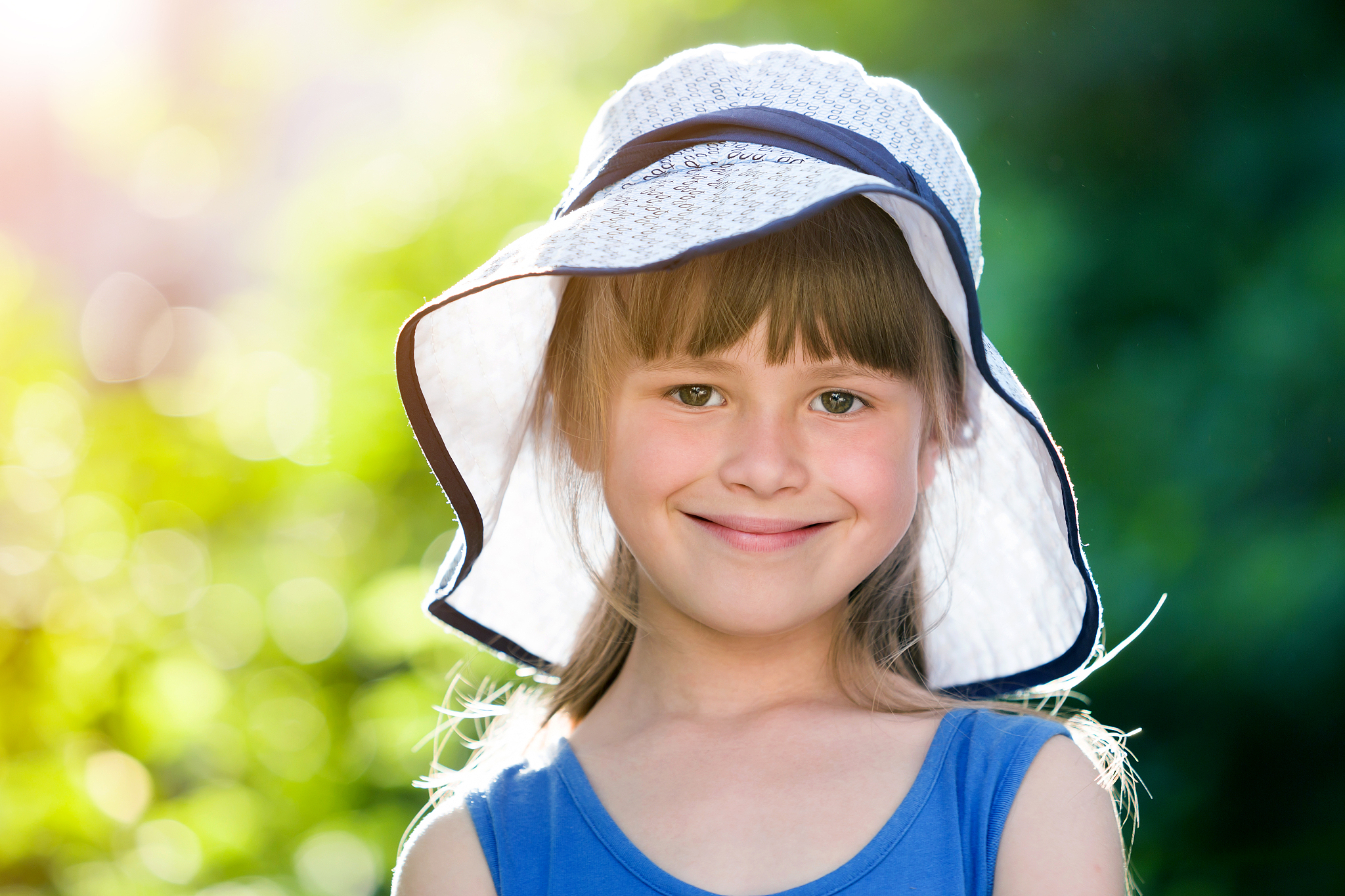 close-up portrait of happy smiling little girl in a big hat. chi