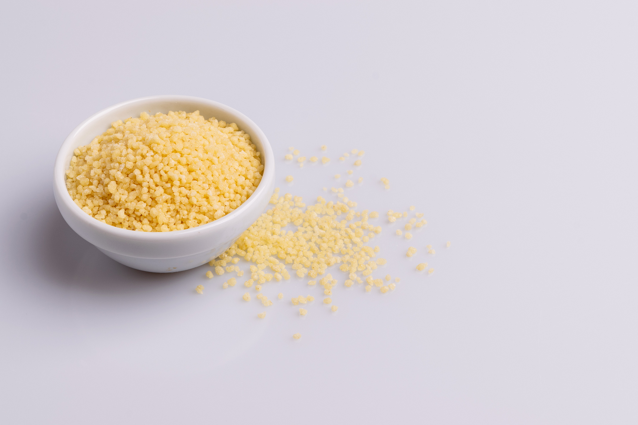 dry couscous isolated on white background, soft light, copy spac