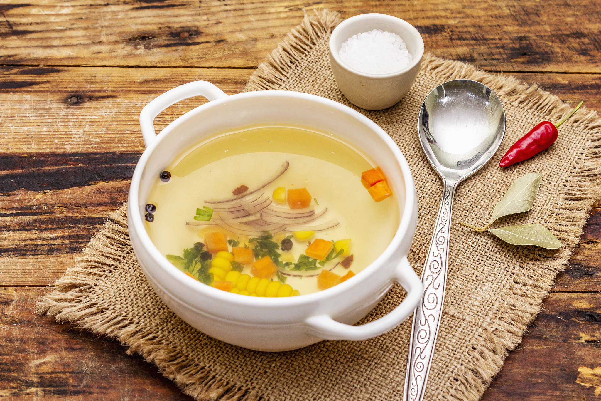 transparent duck broth in bowl with vegetables. traditional boui