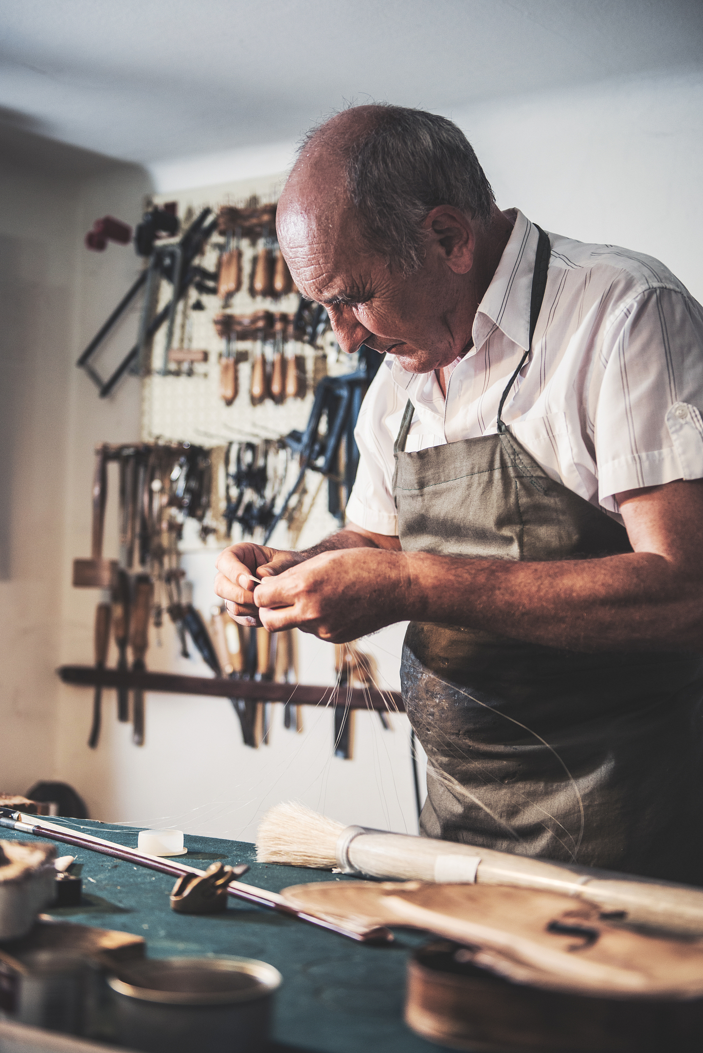 senior man working in music instrument shop