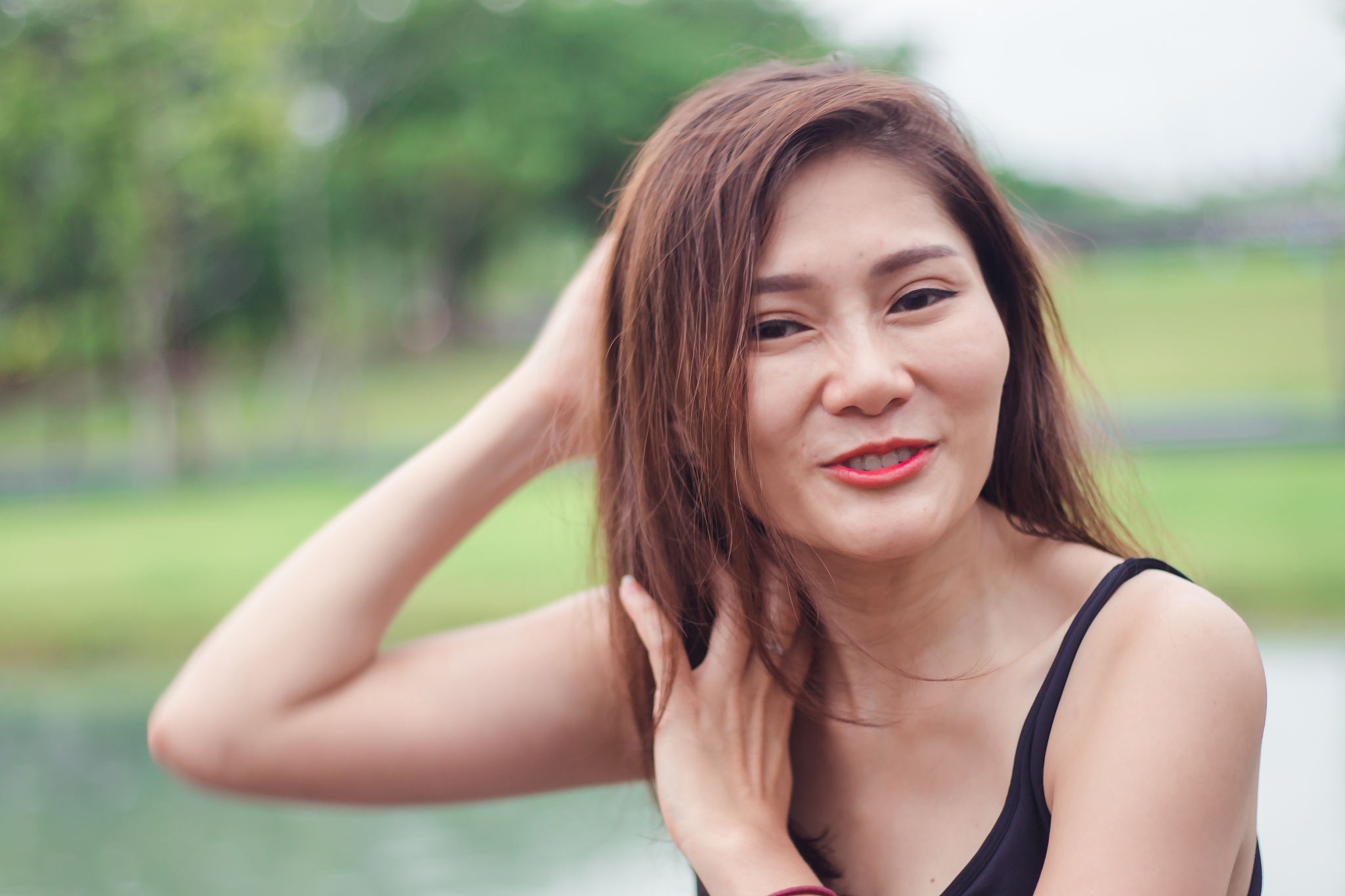 woman is holding her hair and laughing.
