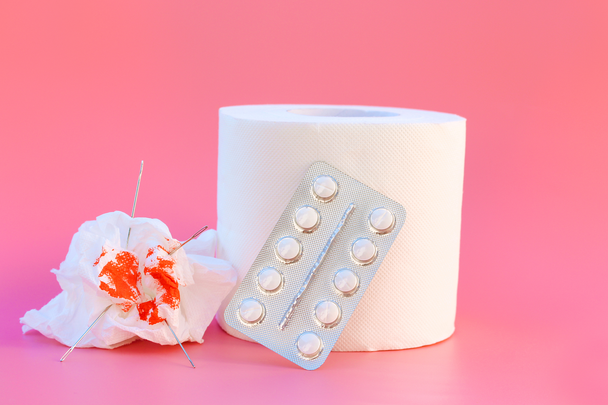 toilet paper, pills and blood. concept of hemorrhoid treatment.