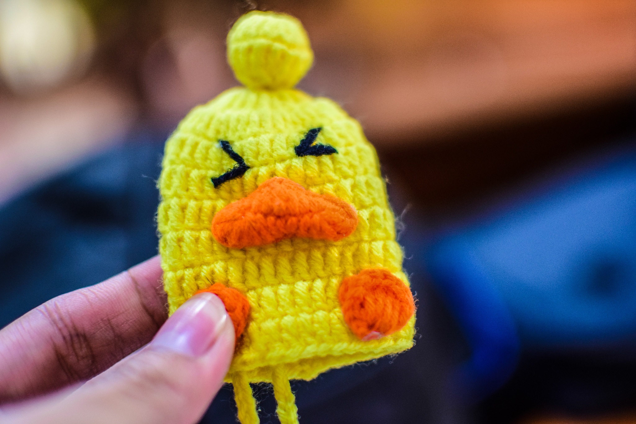 cropped hand holding yellow knit hat