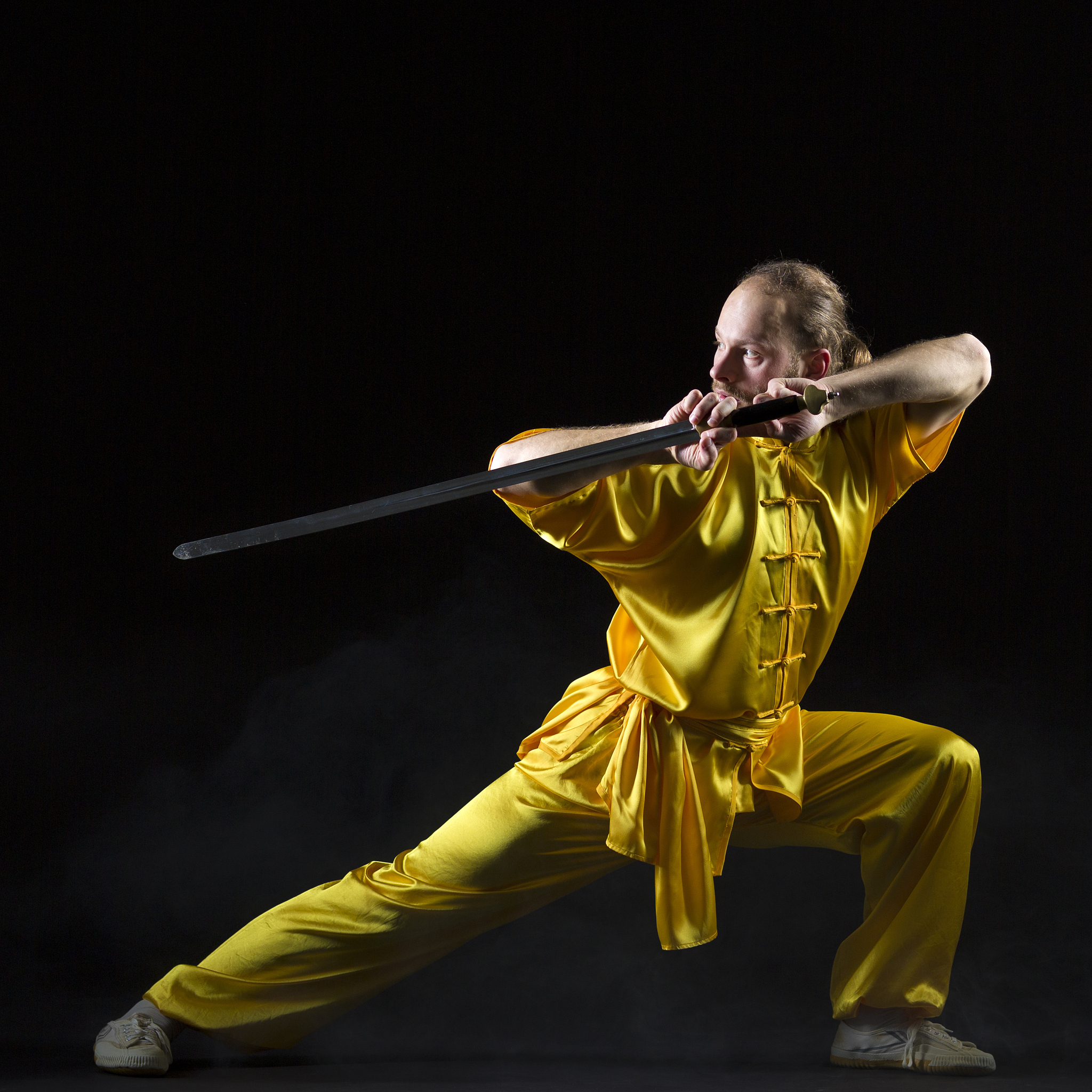 kung fu fighting position with jian sword on dark background