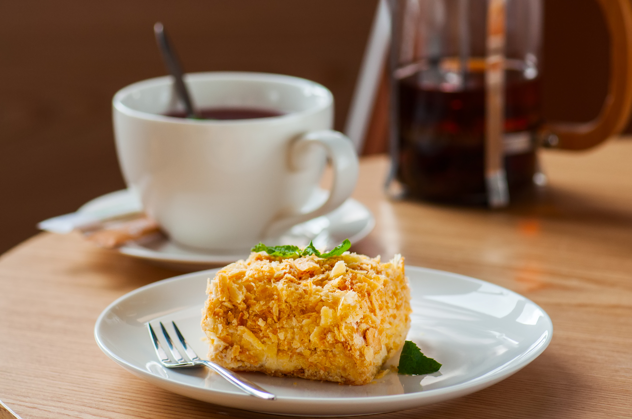 puff pastry cake and cup of tea on table.