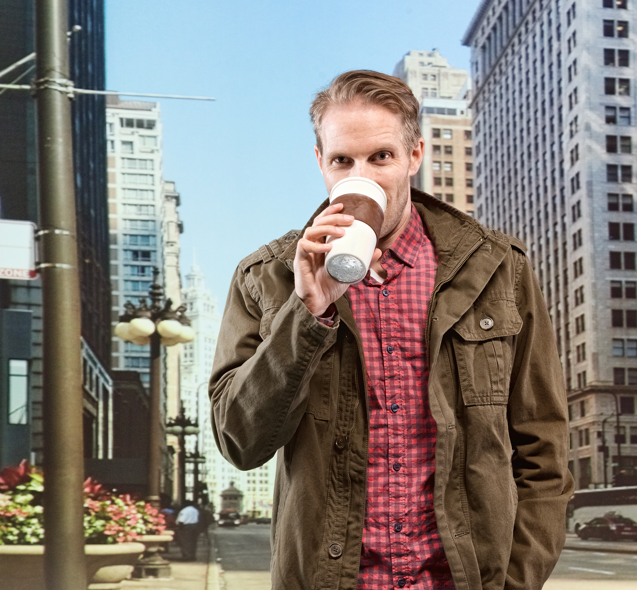 smiling man having coffee in front of city
