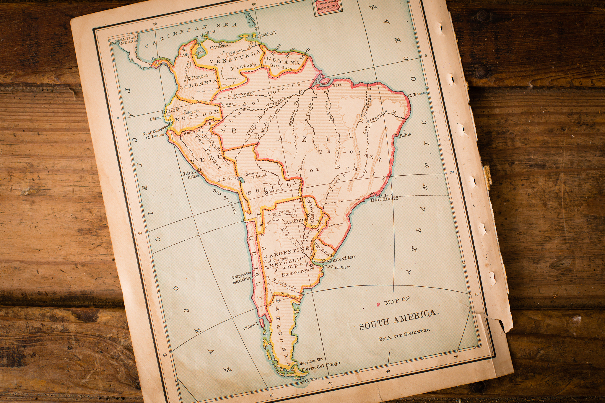 old map of south america, sitting angled on wood trunk