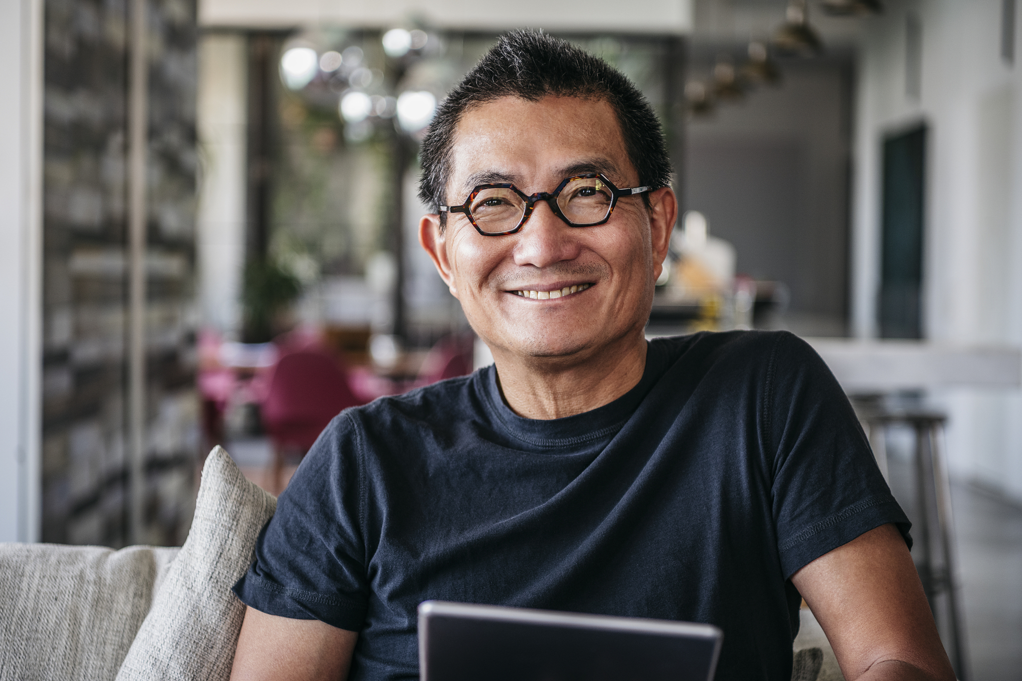 cheerful mature chinese man in glasses smiling towards camera