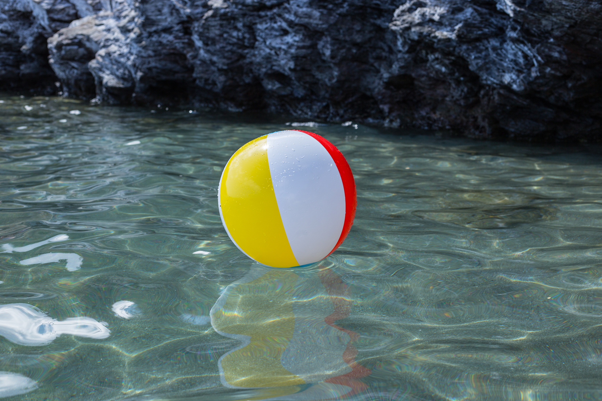 large colorful beach balls on the water in the sea by the beach