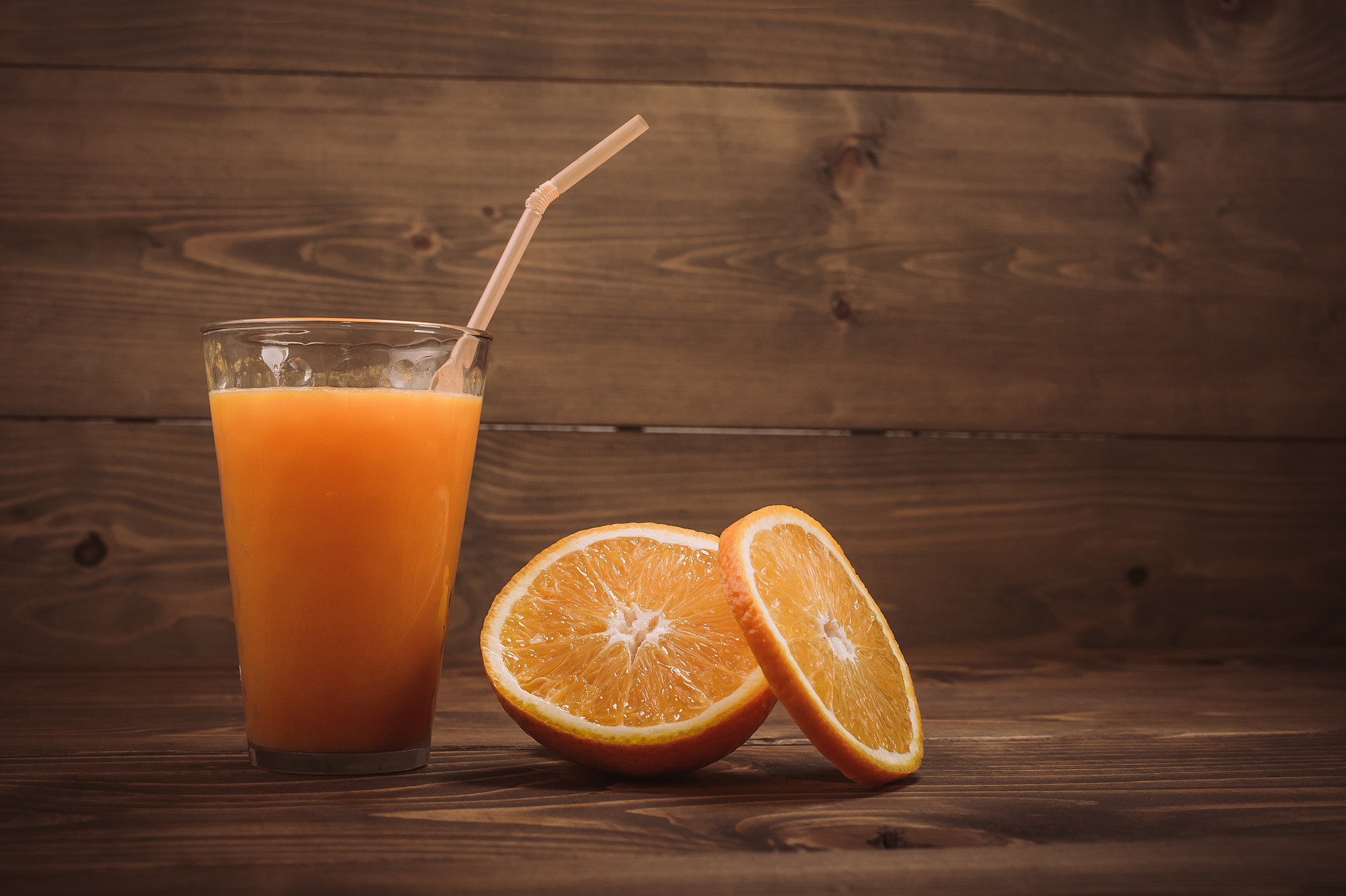orange juice in glass and fresh fruits on wooden background