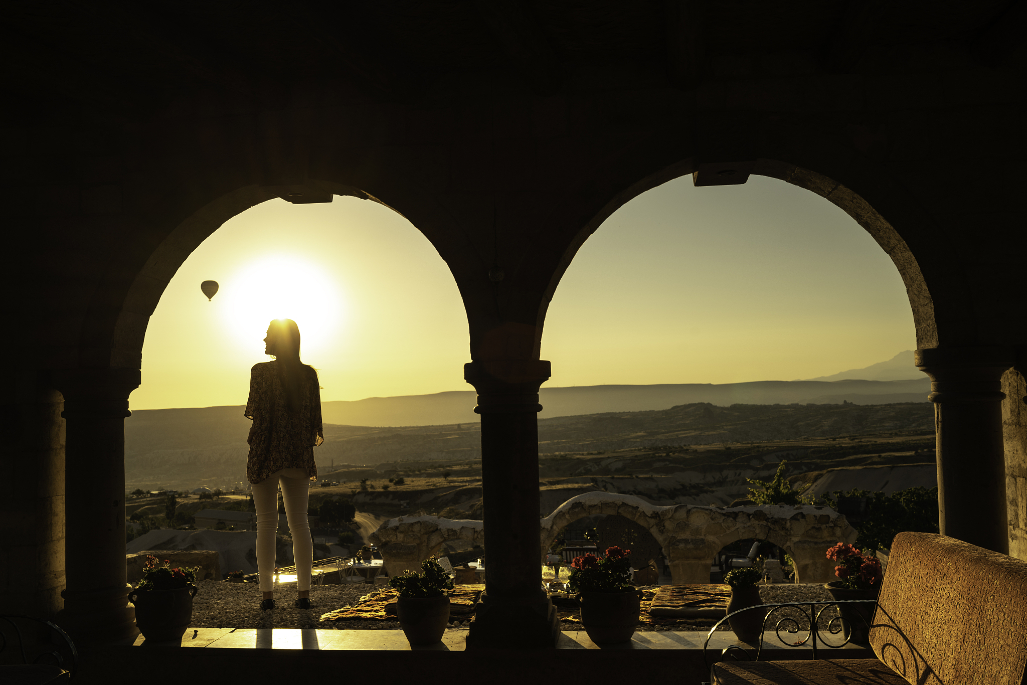 rear view of a young woman standing under archs and looking at v