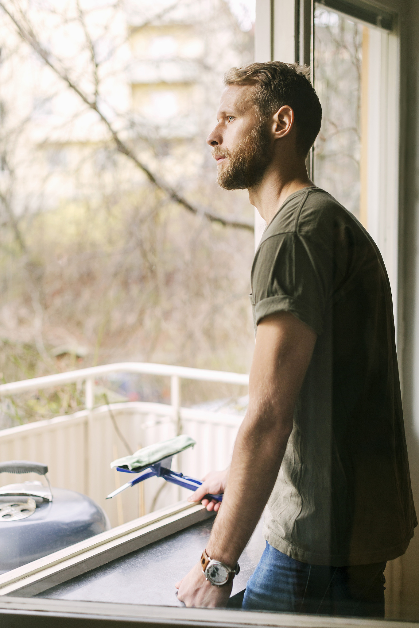 side view of thoughtful man looking through window
