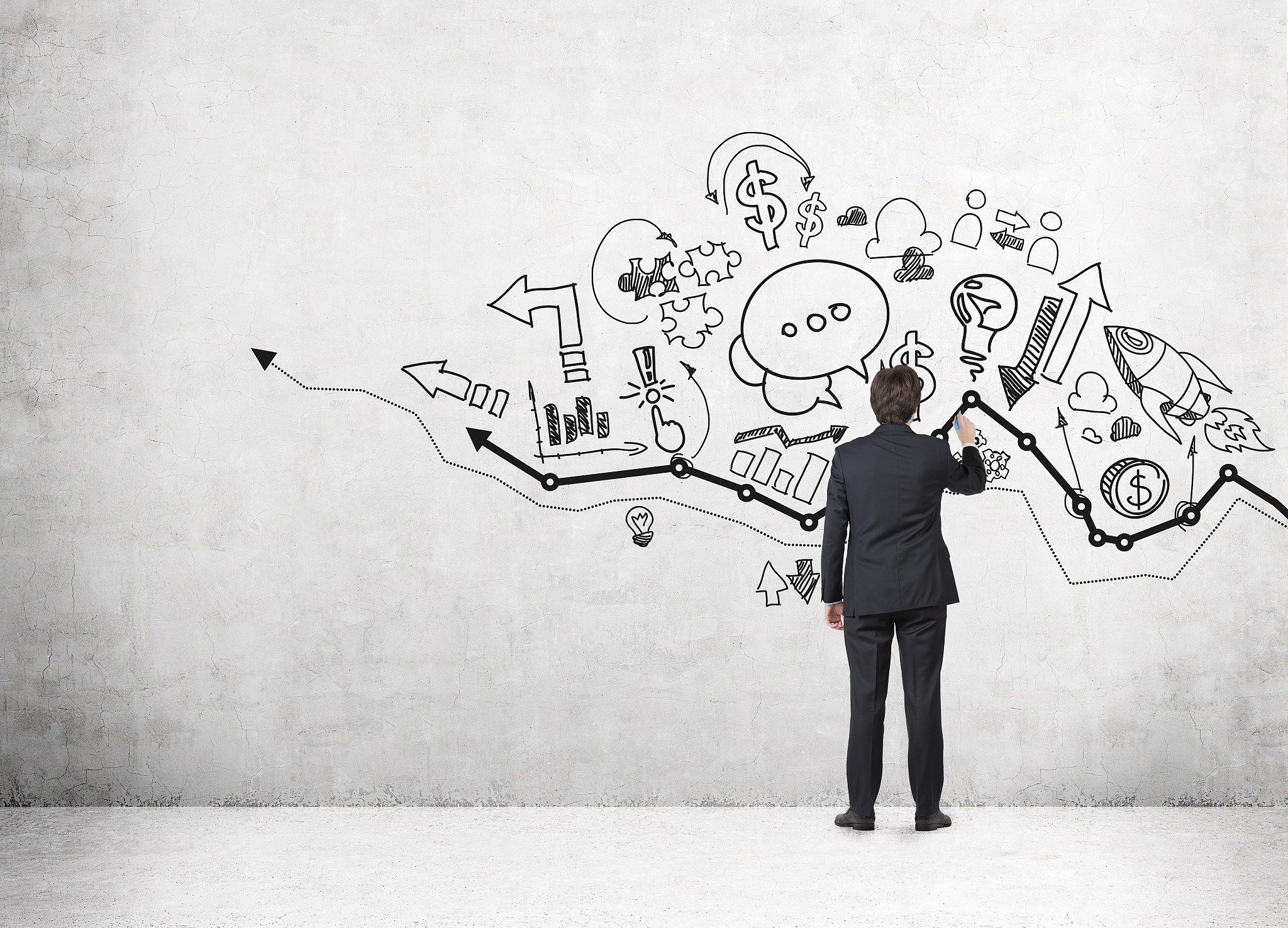 businessman drawing on wall with sketches